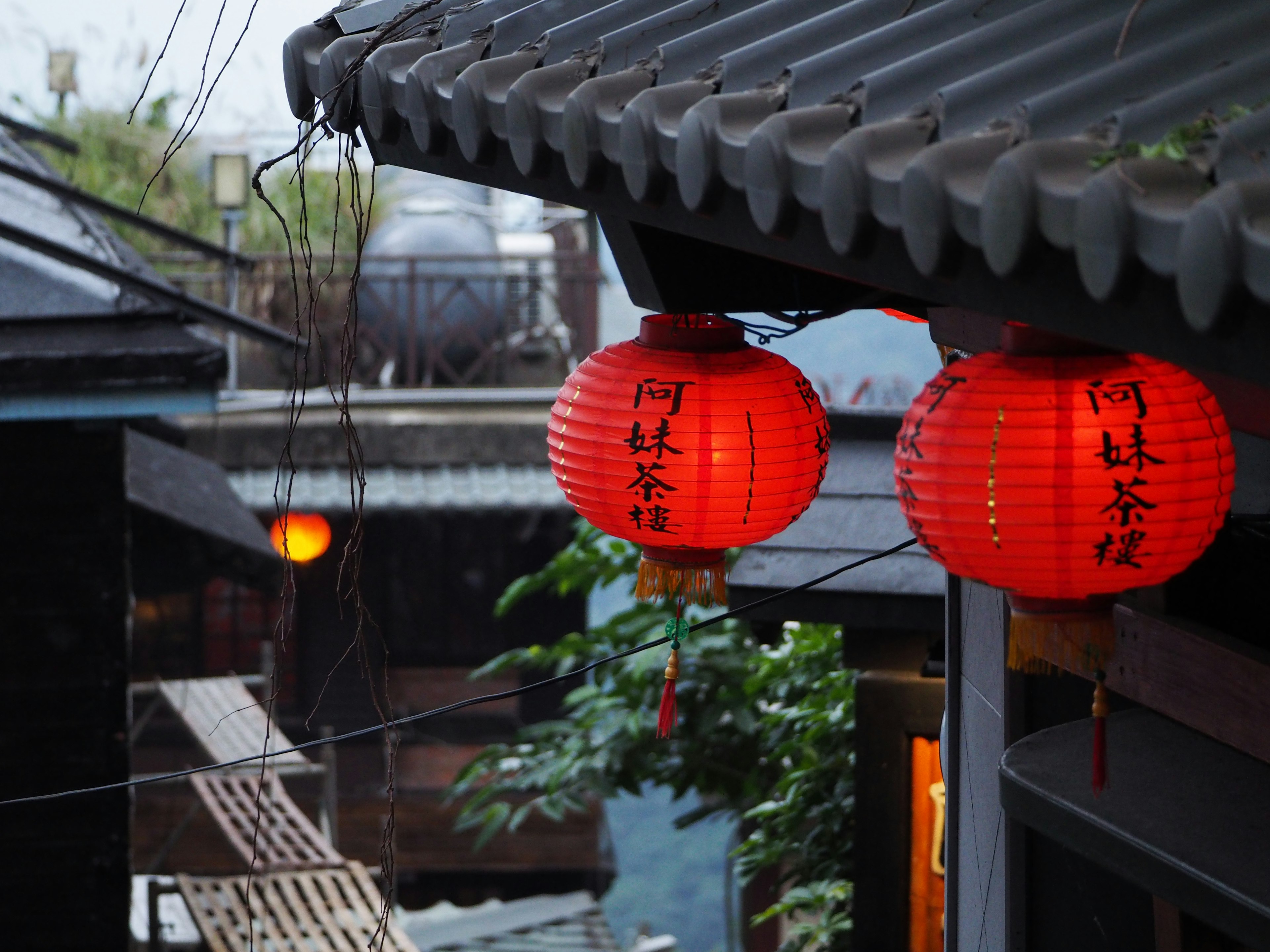 Red lanterns hanging from the roof of an old building