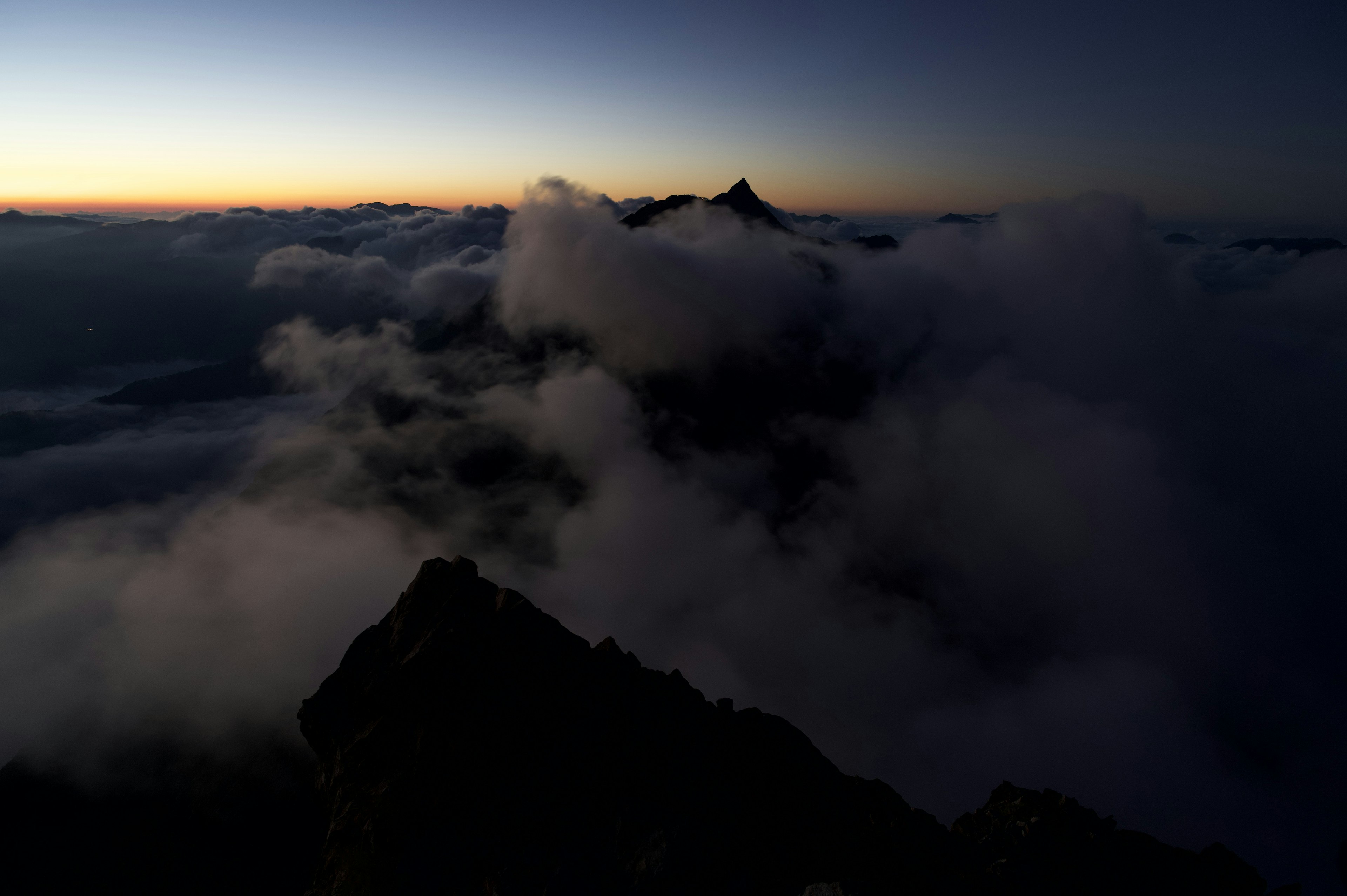 Vista della copertura nuvolosa e del crepuscolo da una cima montuosa