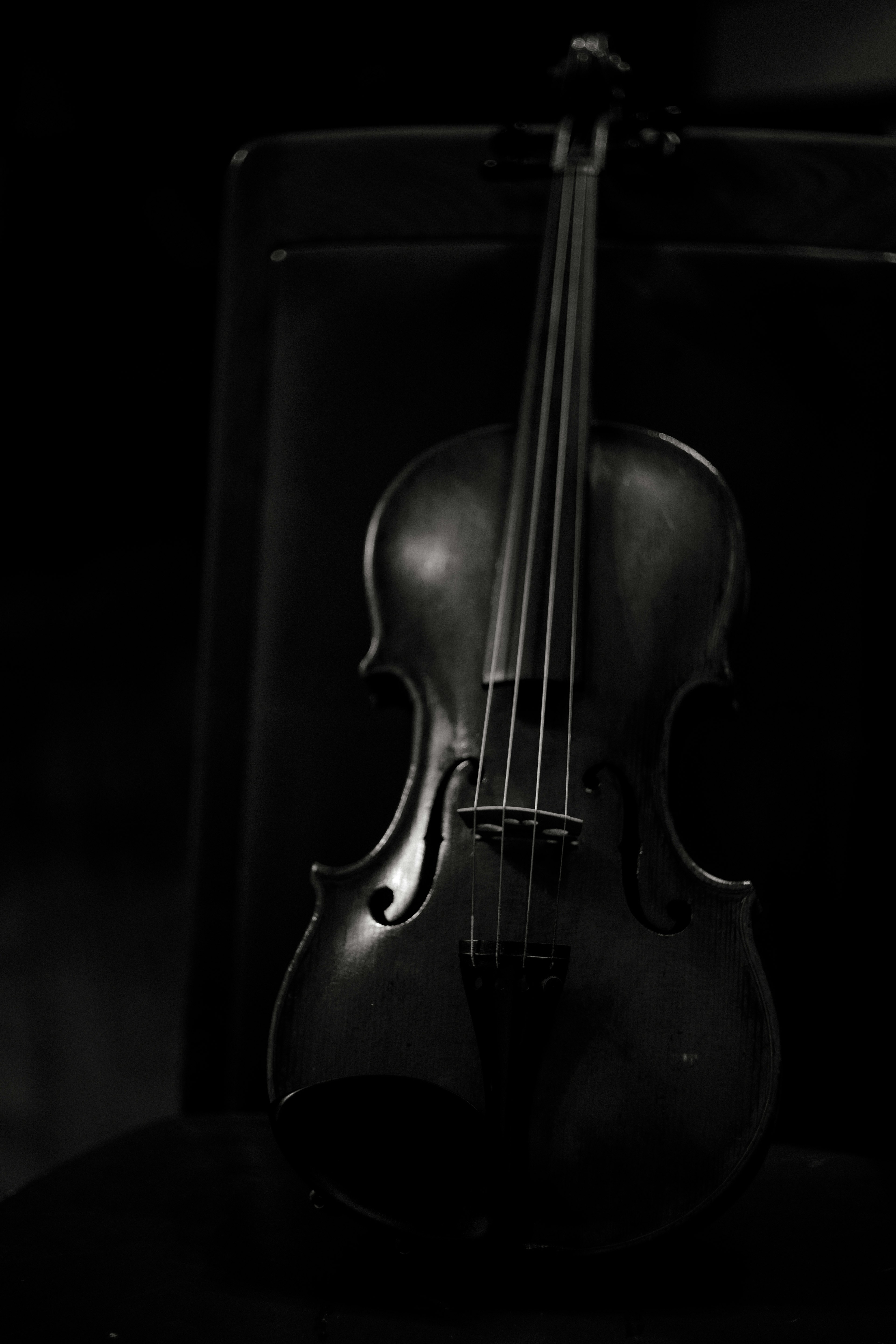 Gros plan d'un violon noir sur un fond sombre