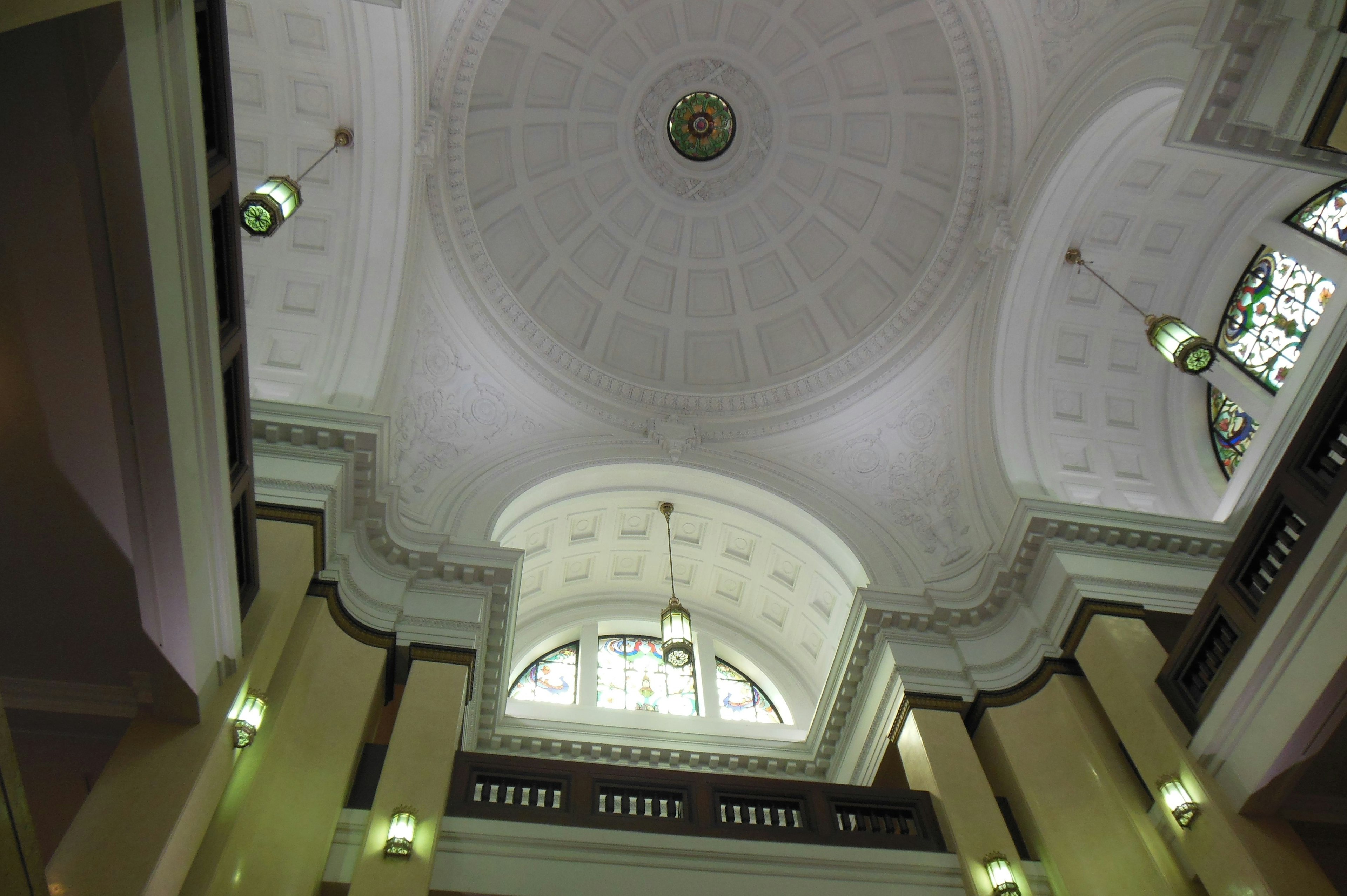 Image looking up at a spacious building interior with a decorative ceiling