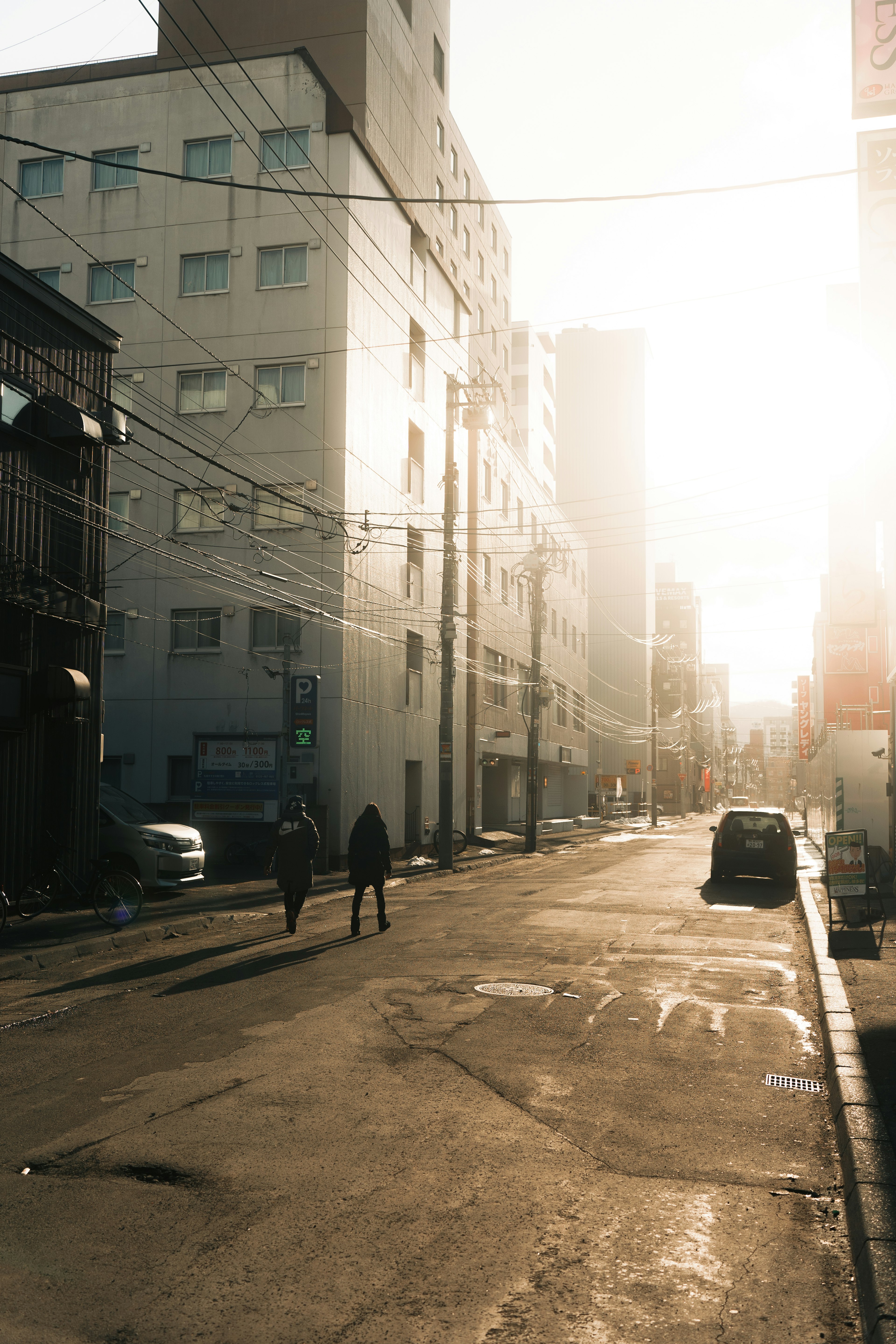 Scena di strada con edifici in silhouette e persone al tramonto