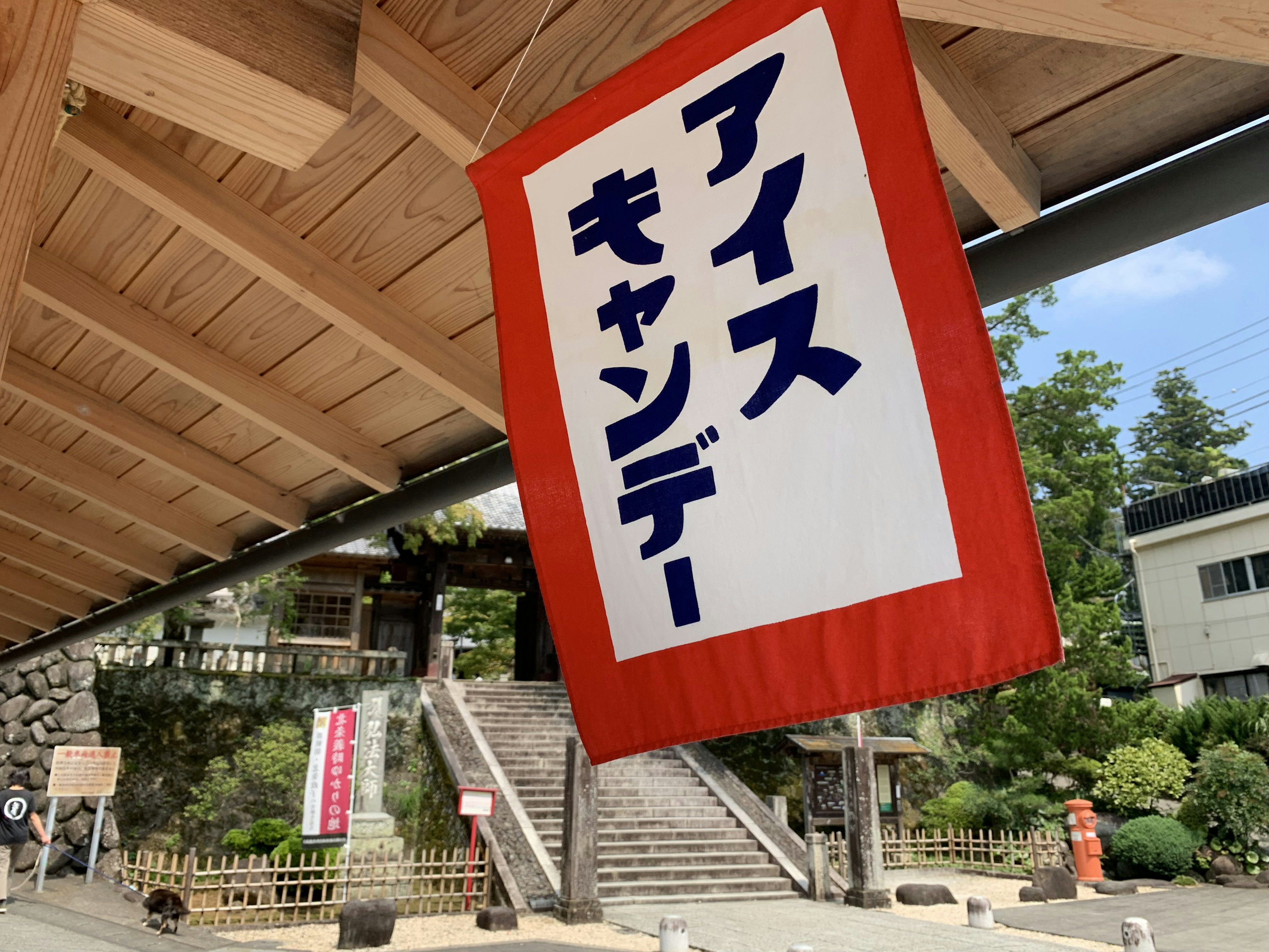 A sign for ice candy hanging in a scenic area