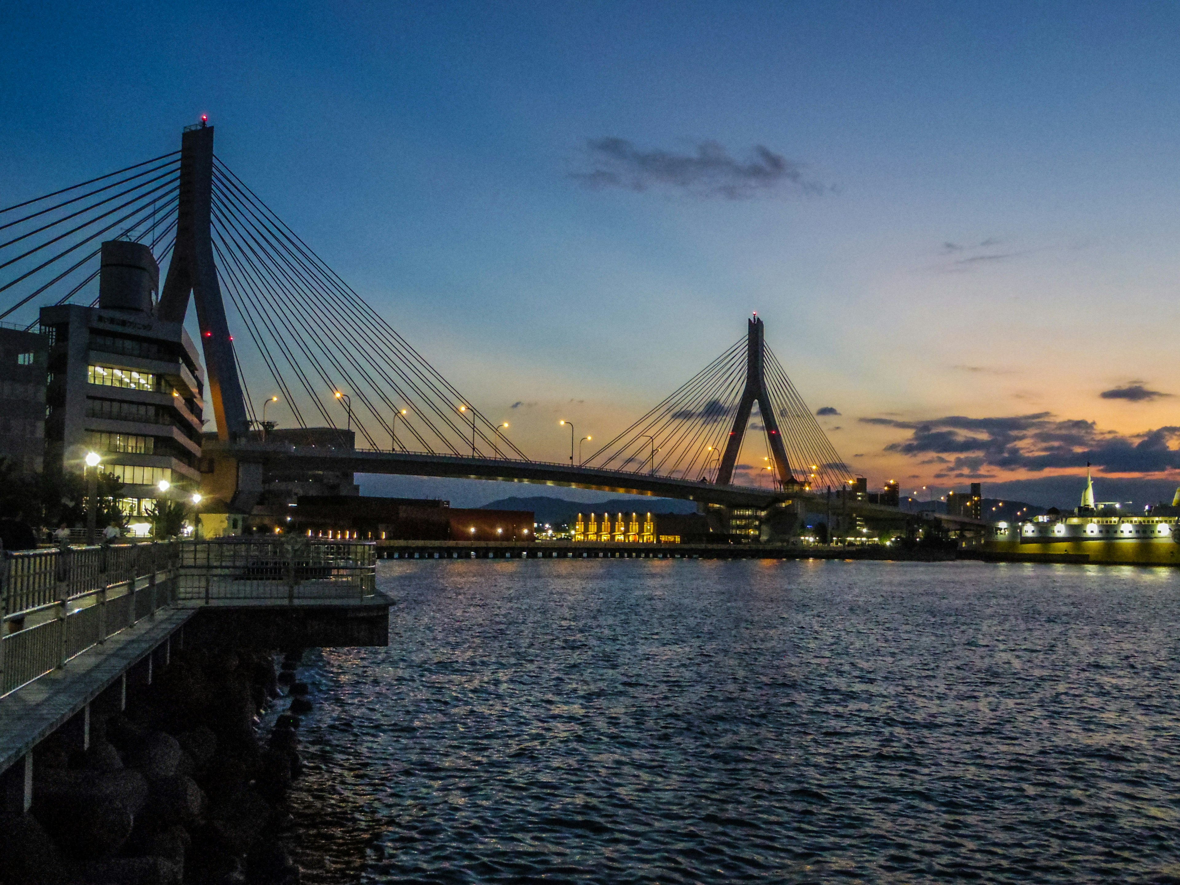 Malersicher Blick auf eine Hängebrücke über einen Fluss bei Sonnenuntergang