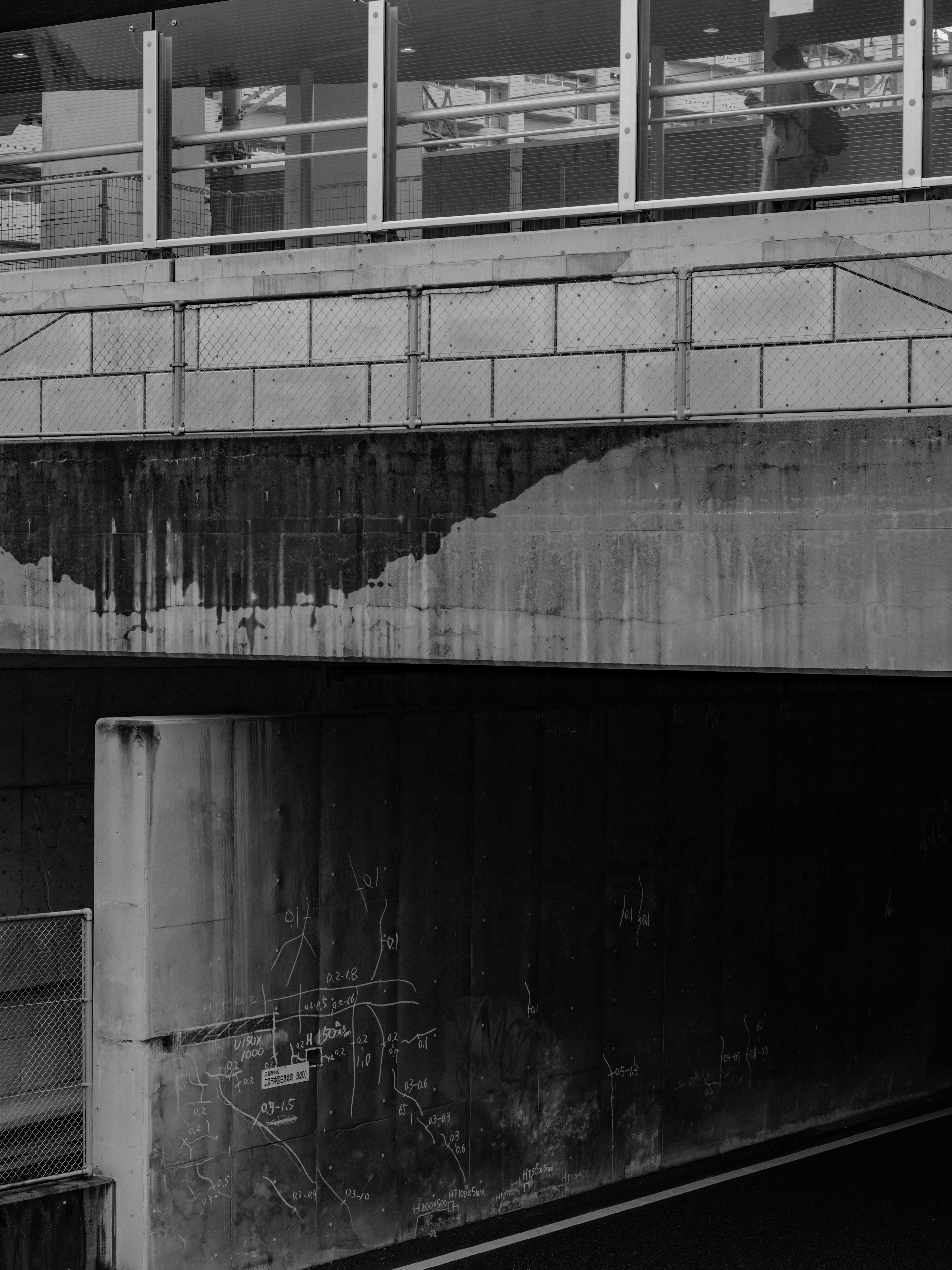 Black and white urban landscape featuring a concrete bridge and the water surface below