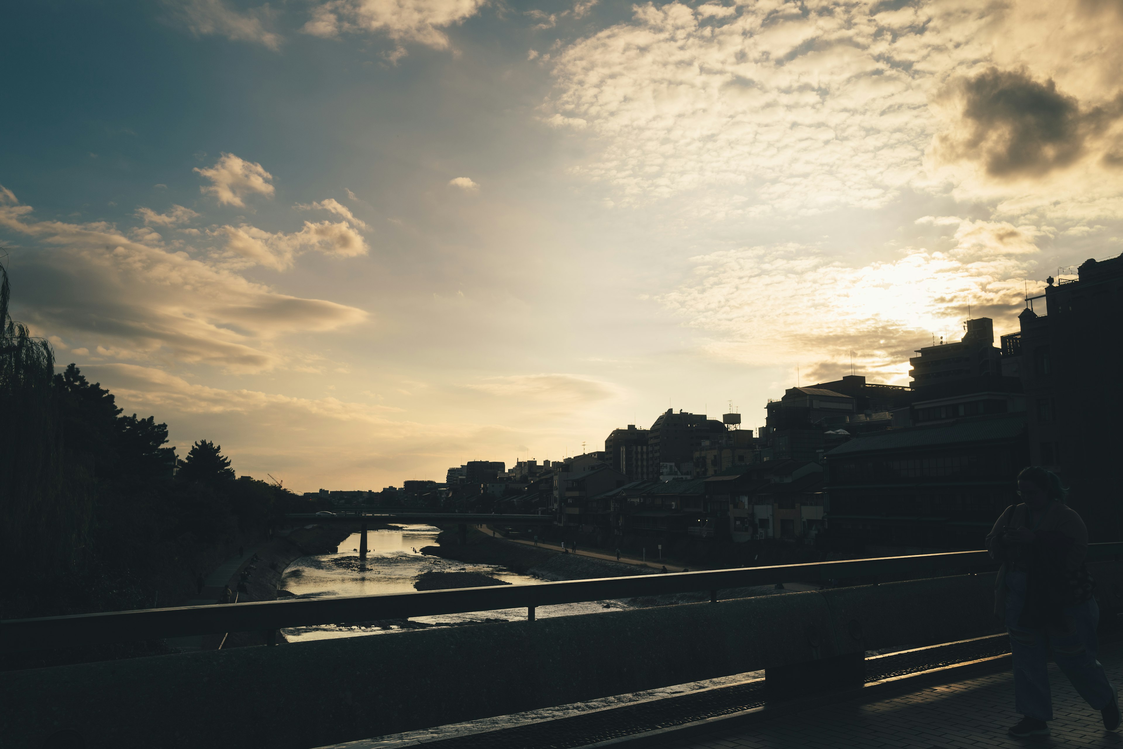 Silhouette di edifici contro un tramonto su un fiume