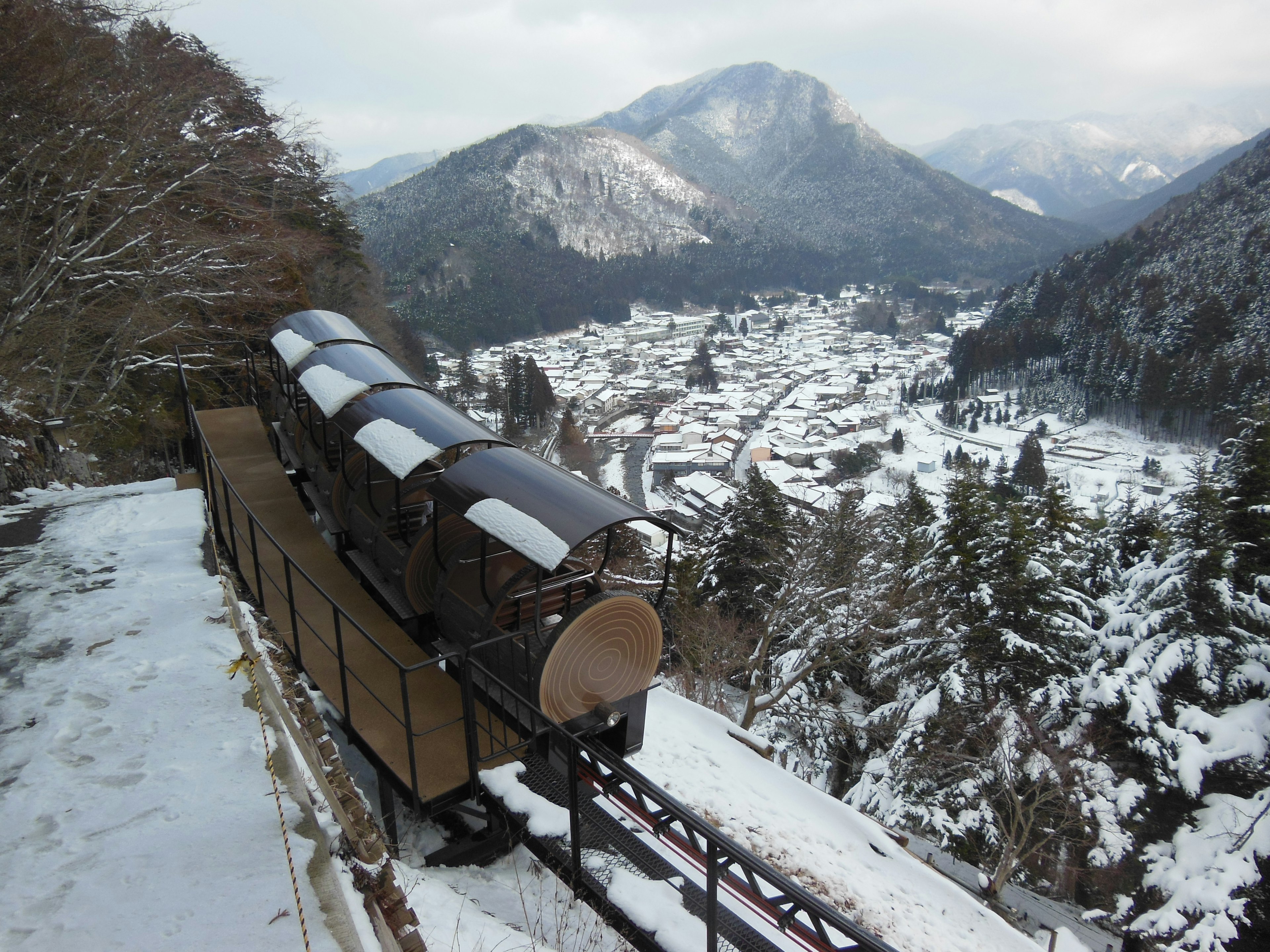 雪に覆われた山々と村を背景にした列車