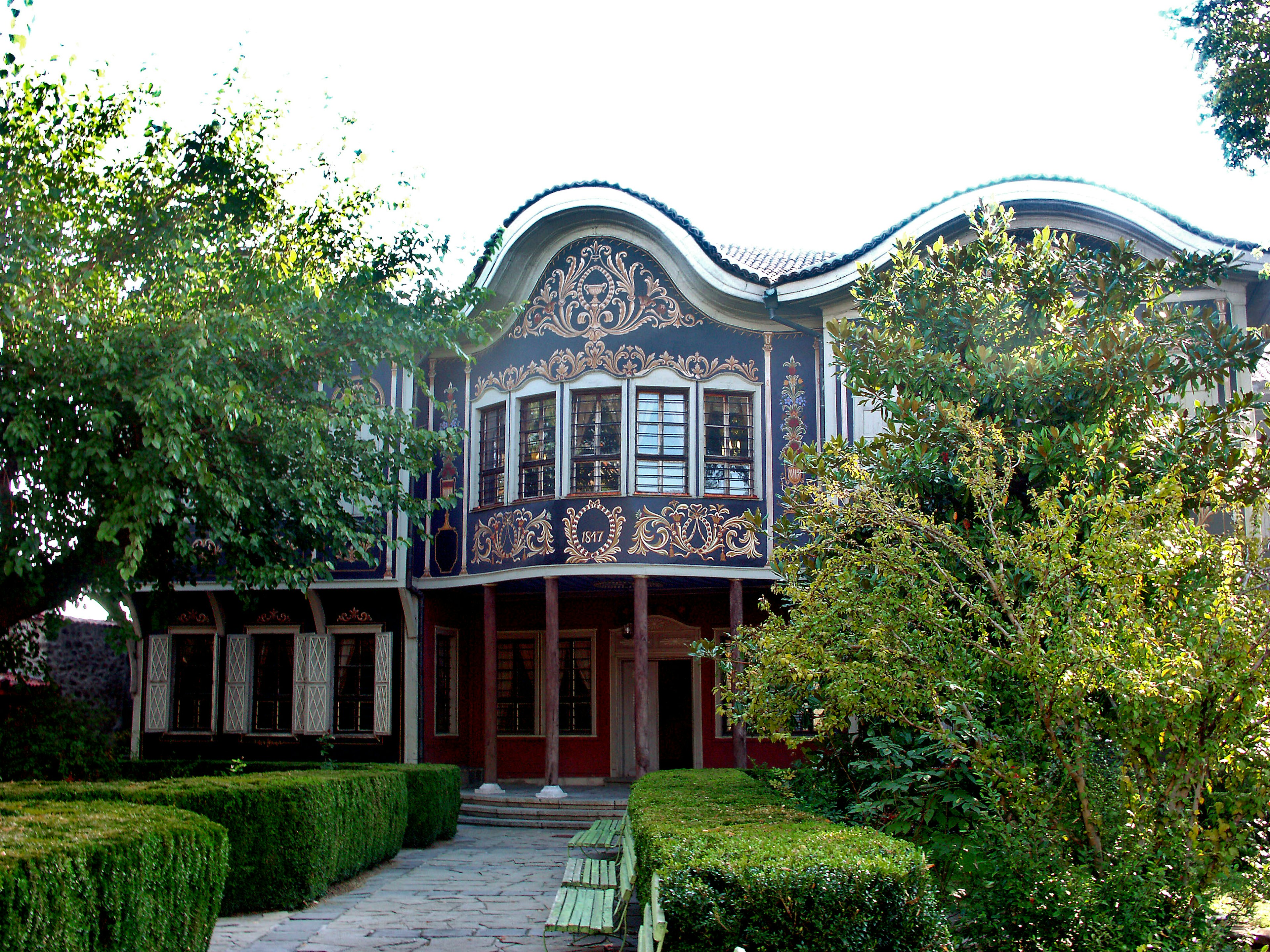 Decorative facade of a house surrounded by lush greenery