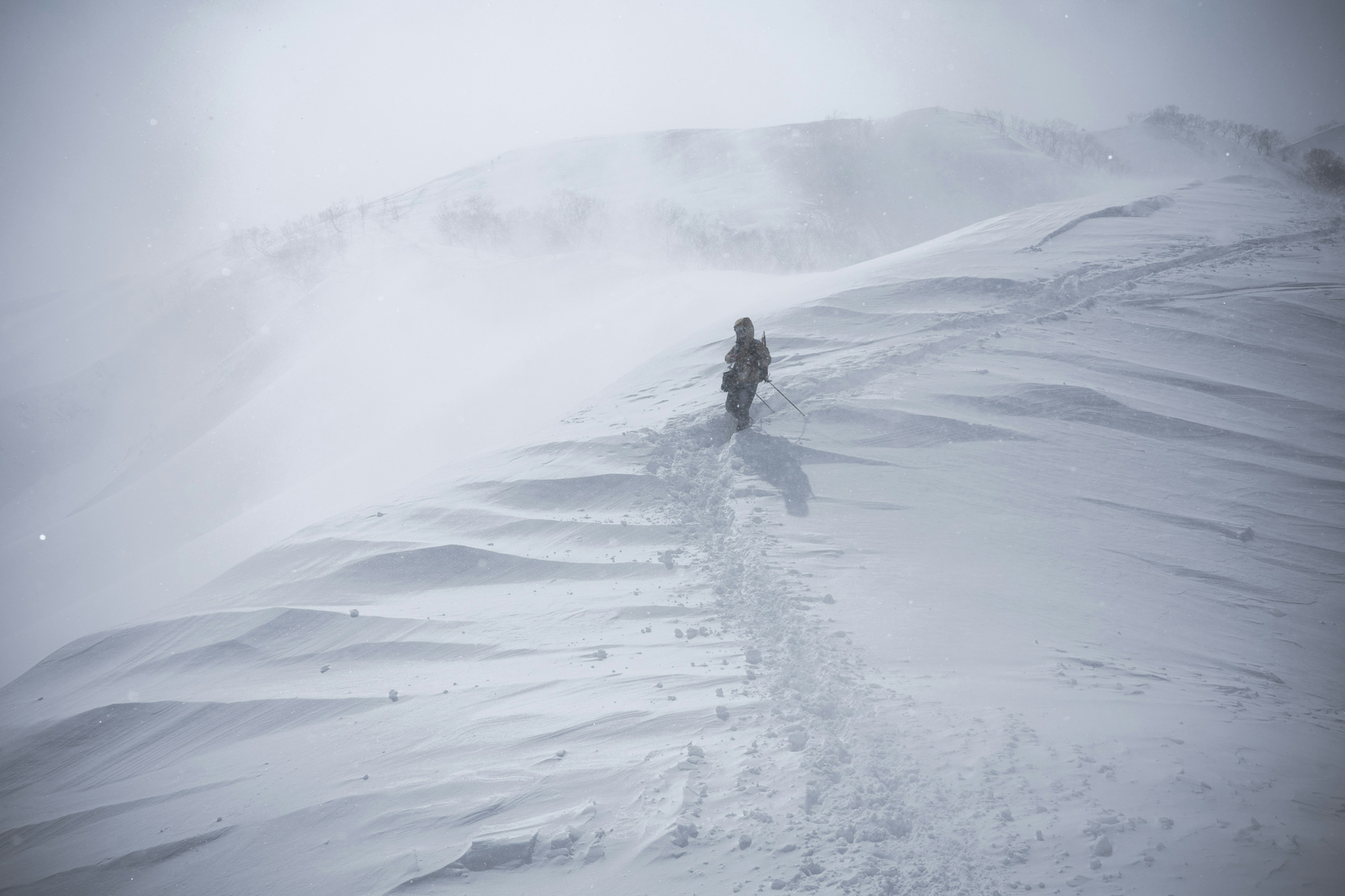 Silhouette d'une personne marchant sur un chemin de montagne enneigé