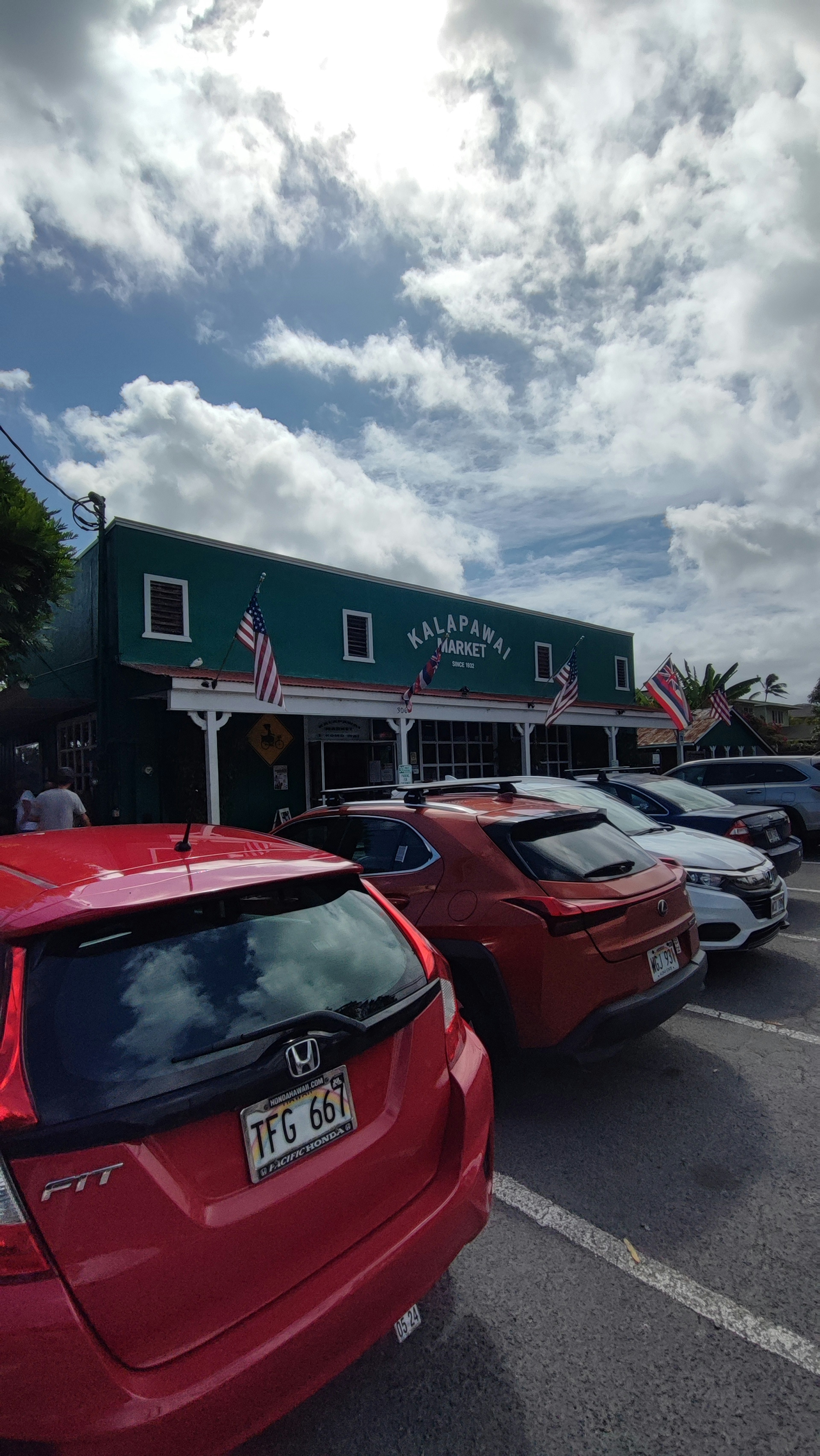 Exterior of a restaurant with green walls and parked cars