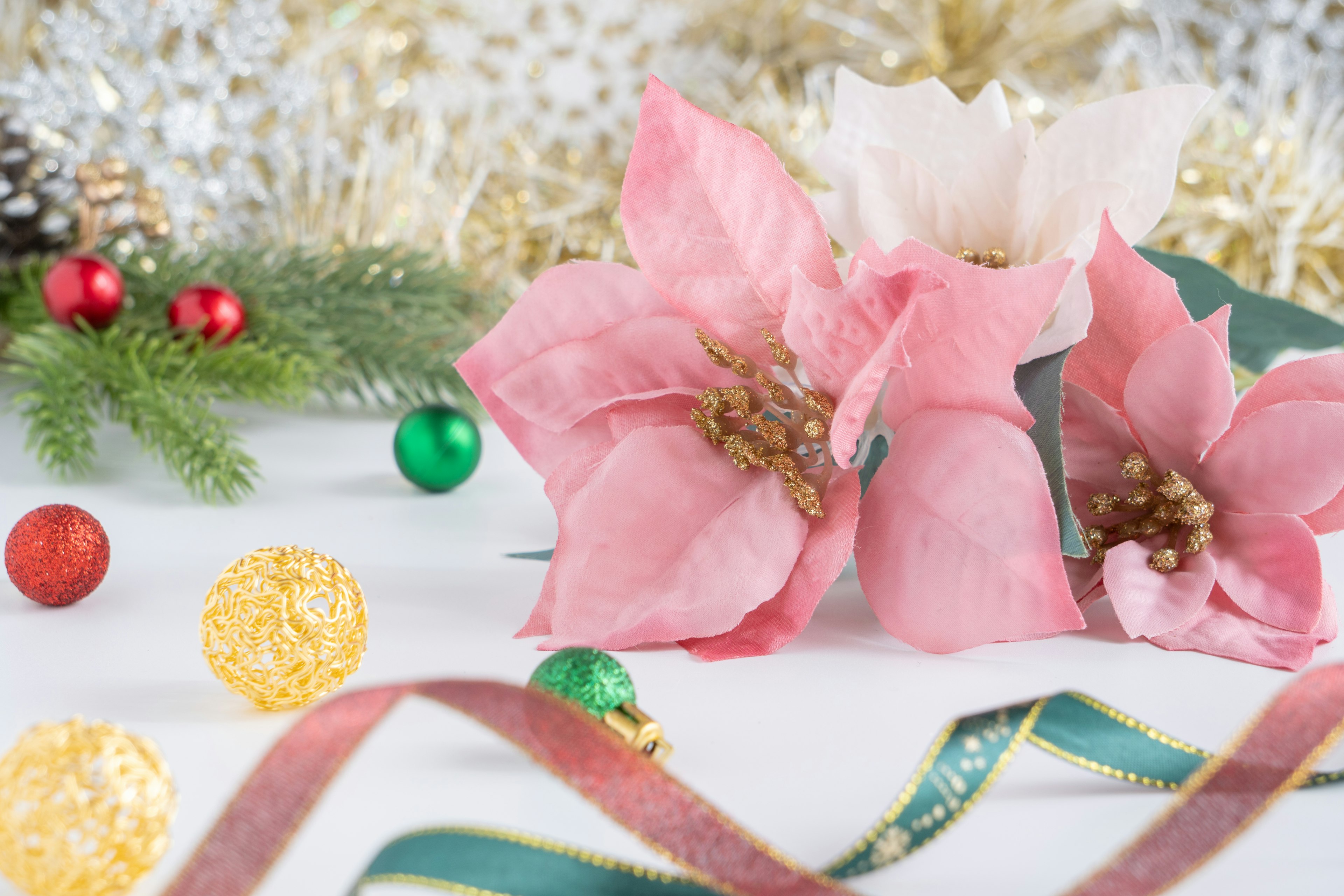 クリスマスの装飾が施されたピンクの花とカラフルなオーナメント