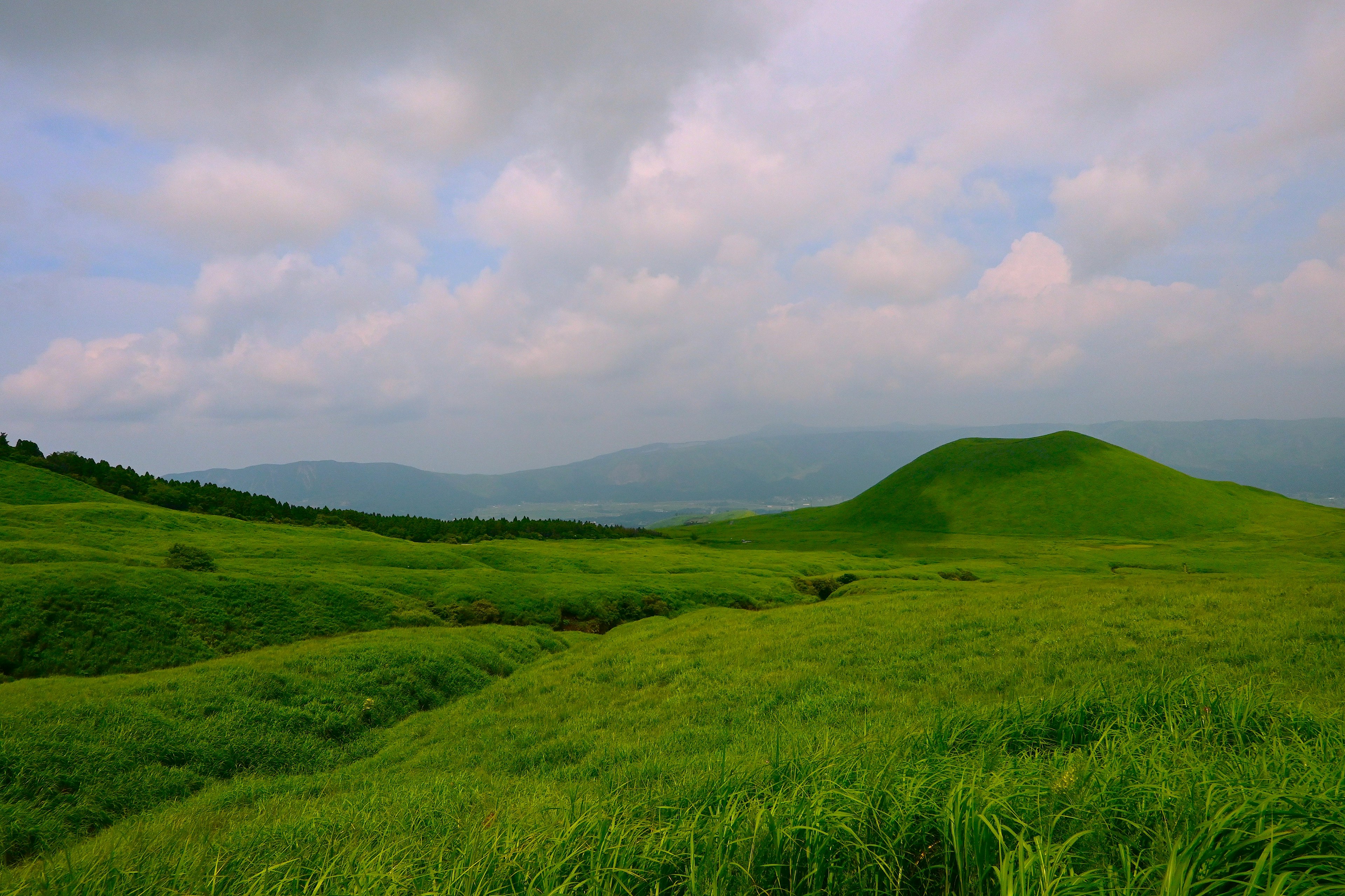 Lush green hills under a cloudy sky