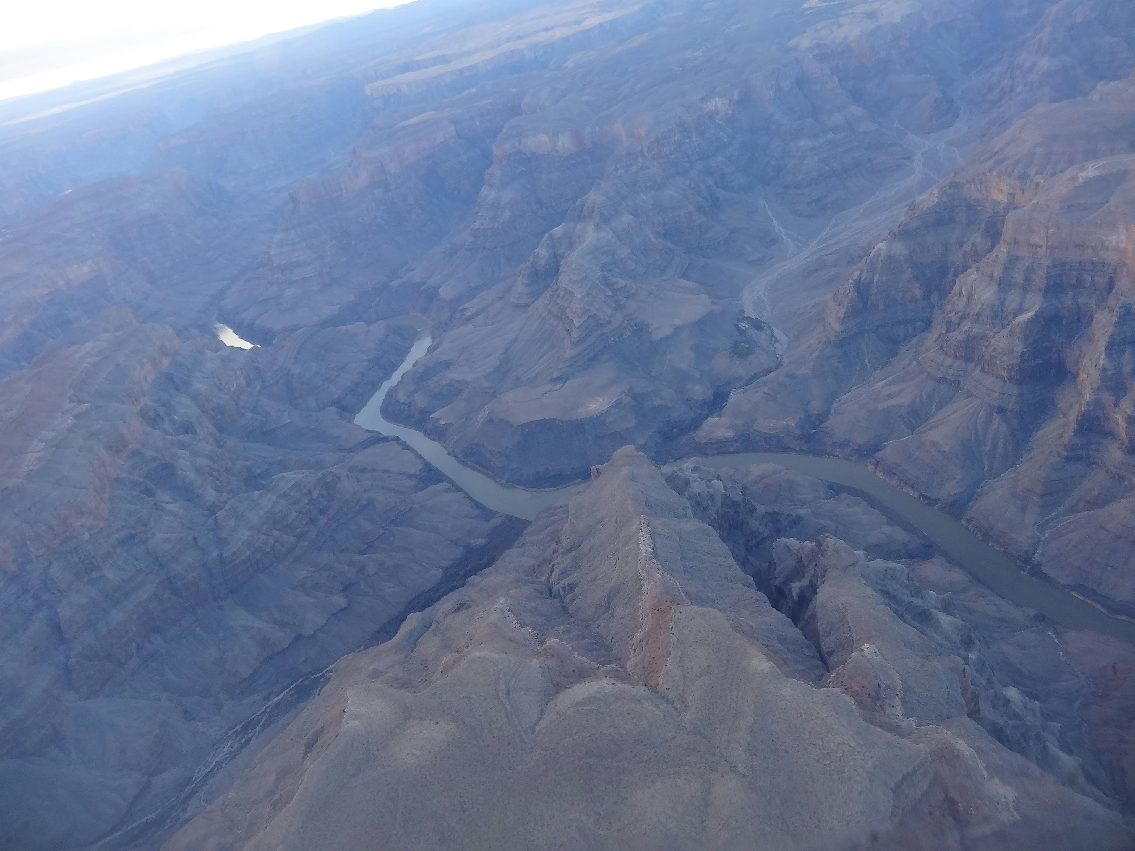 Vista aérea del Gran Cañón mostrando montañas majestuosas y un río sinuoso