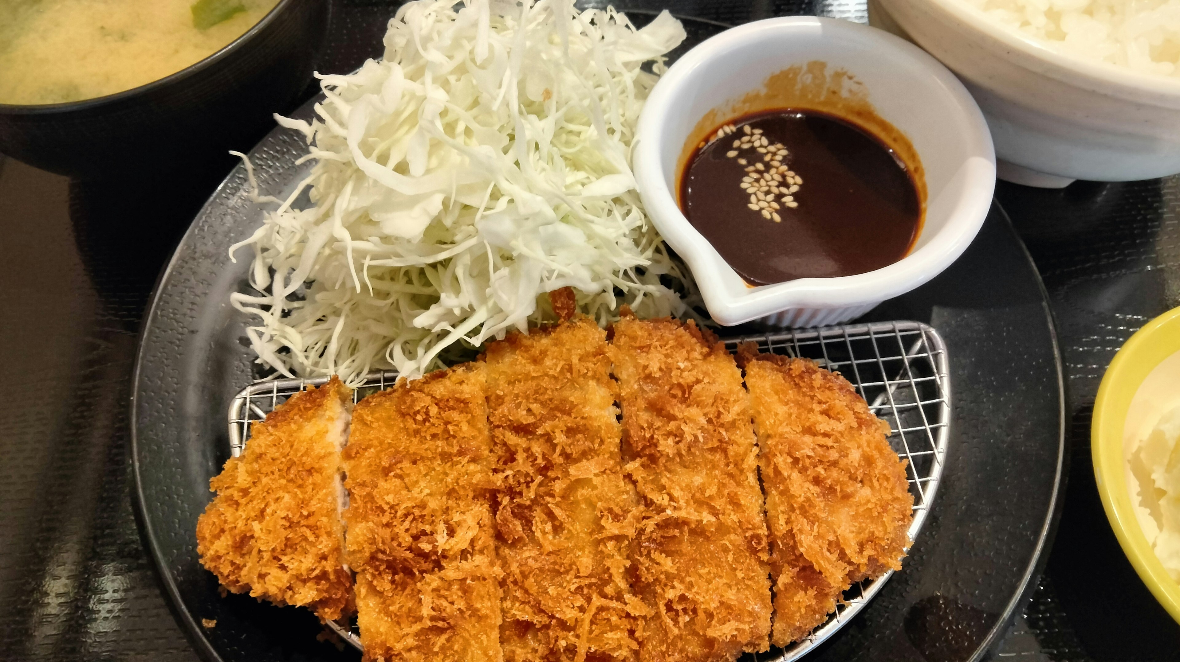 Teller mit frittiertem Tonkatsu, gehobeltem Kohl und Dip-Sauce