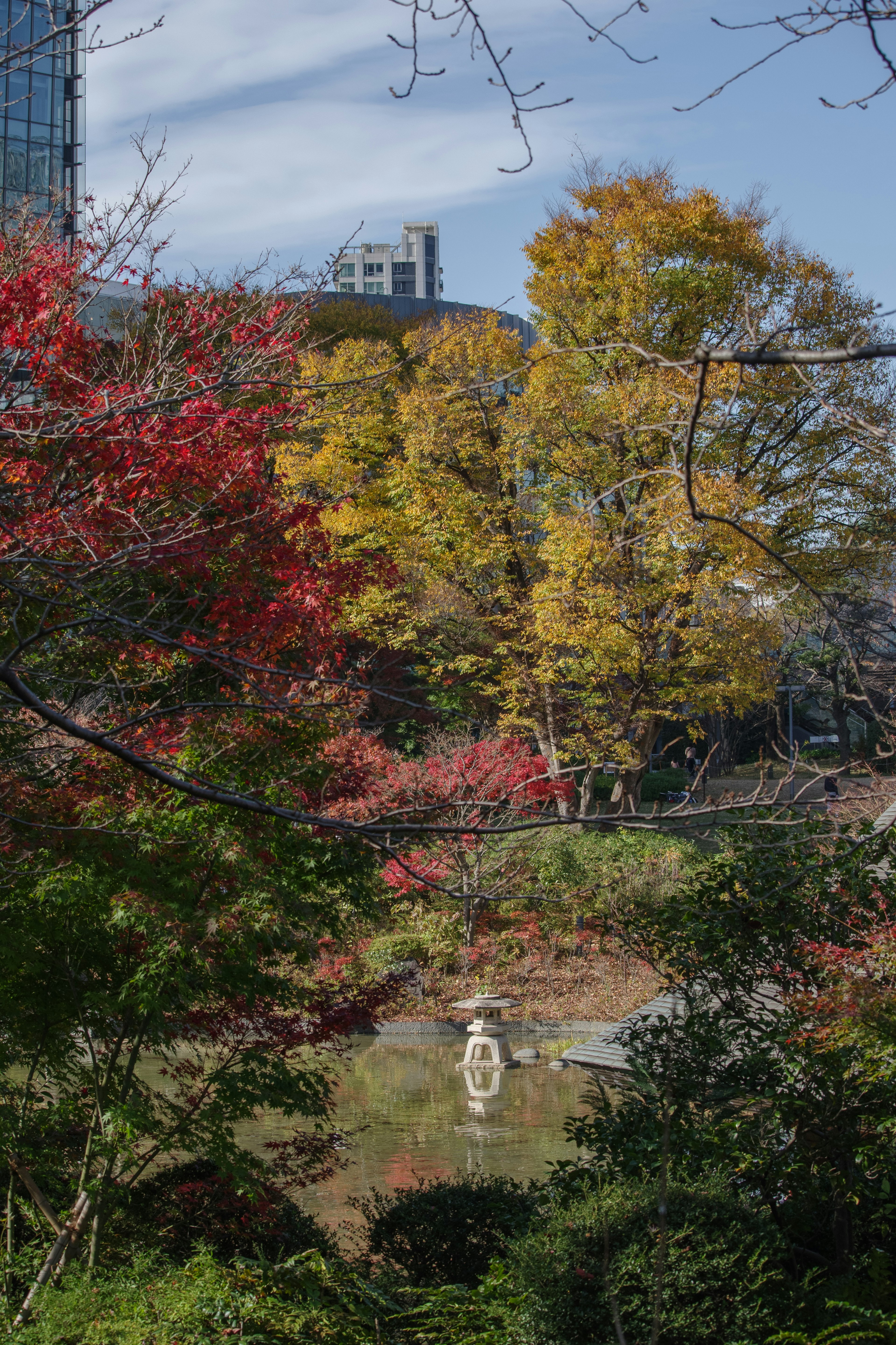 Scenic view of a pond reflecting colorful trees and a sculpture