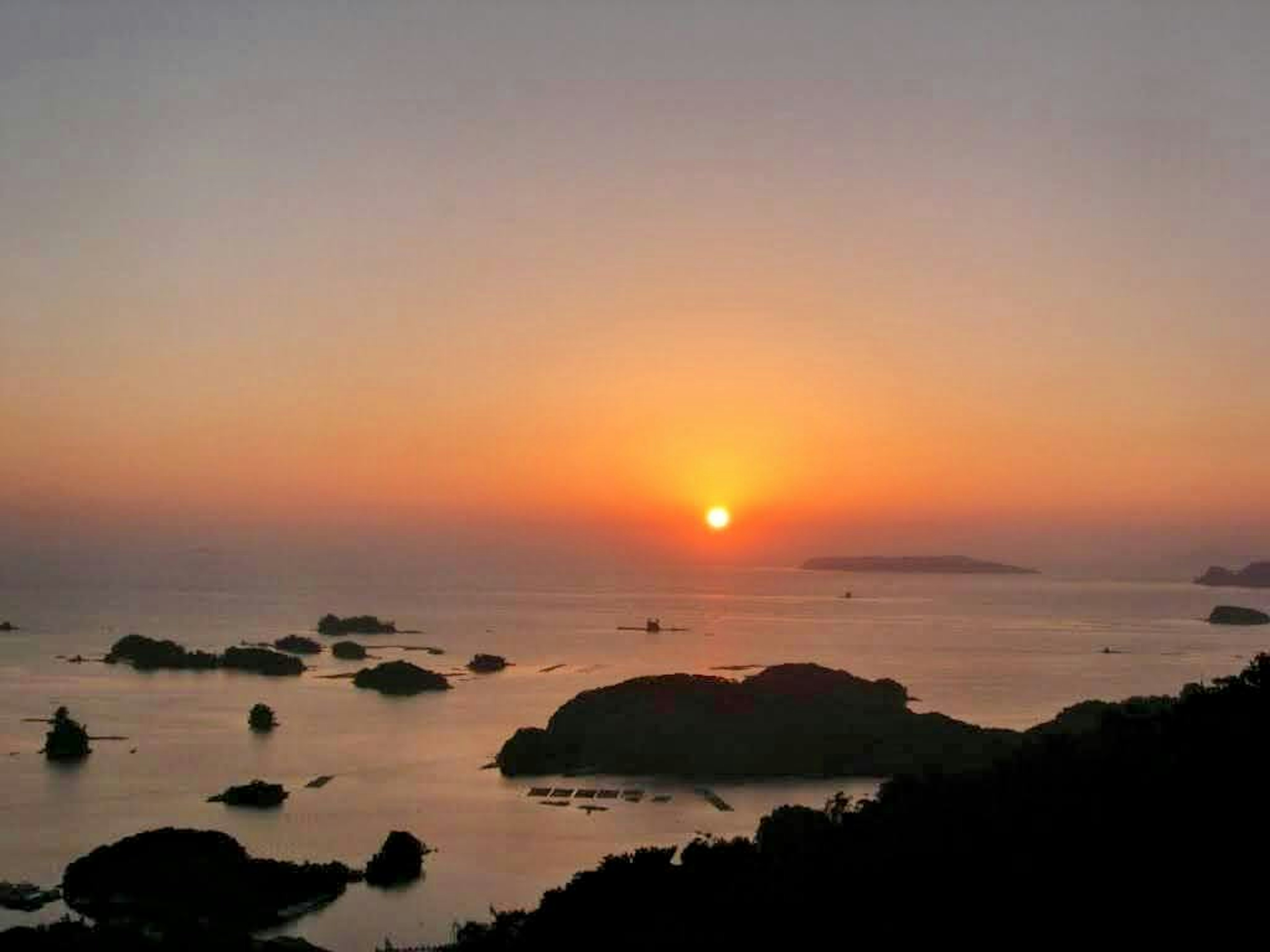 Schöne Landschaft mit Sonnenuntergang über dem Meer mit felsiger Küste und ruhigem Wasser