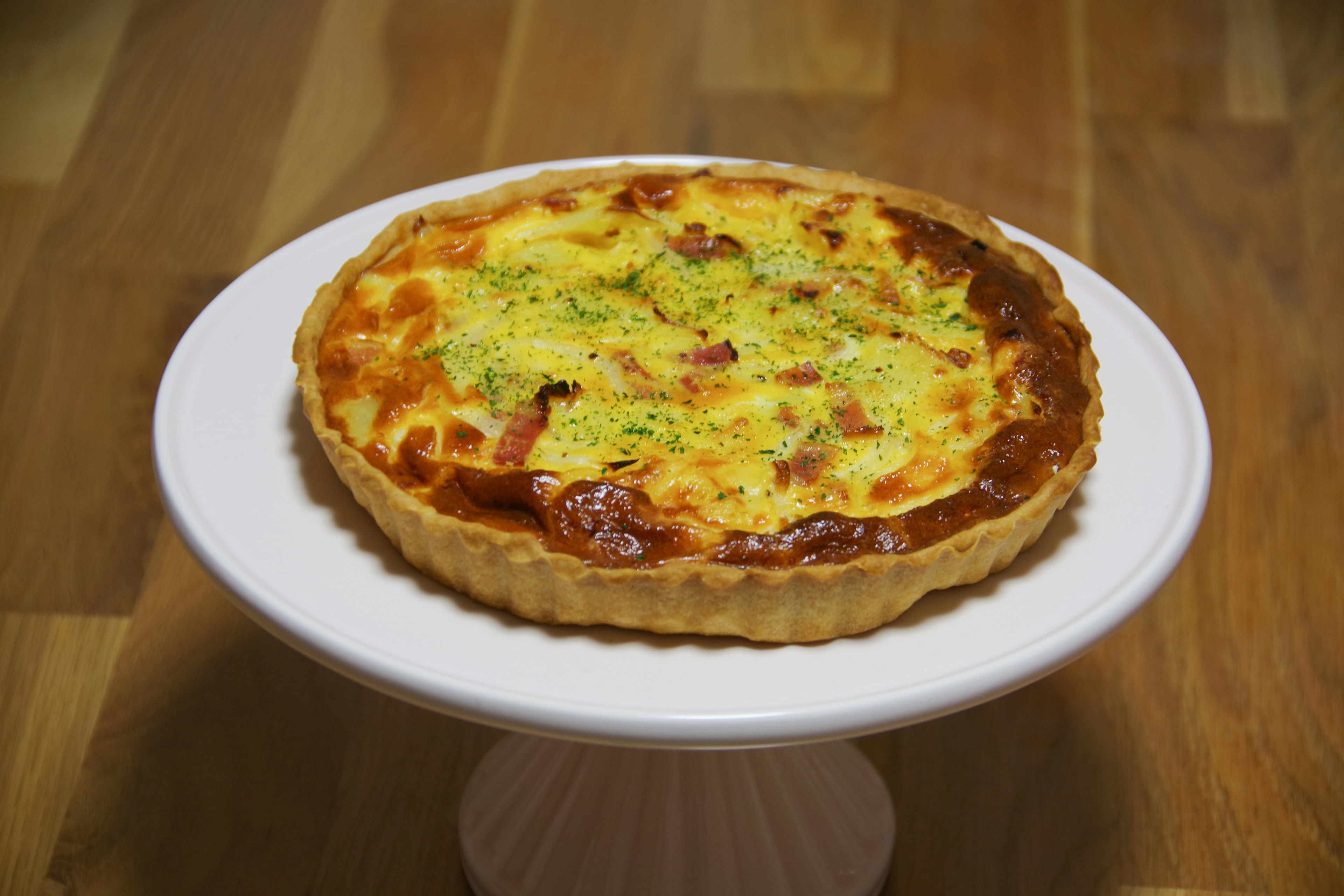 Delicious quiche on a white cake stand