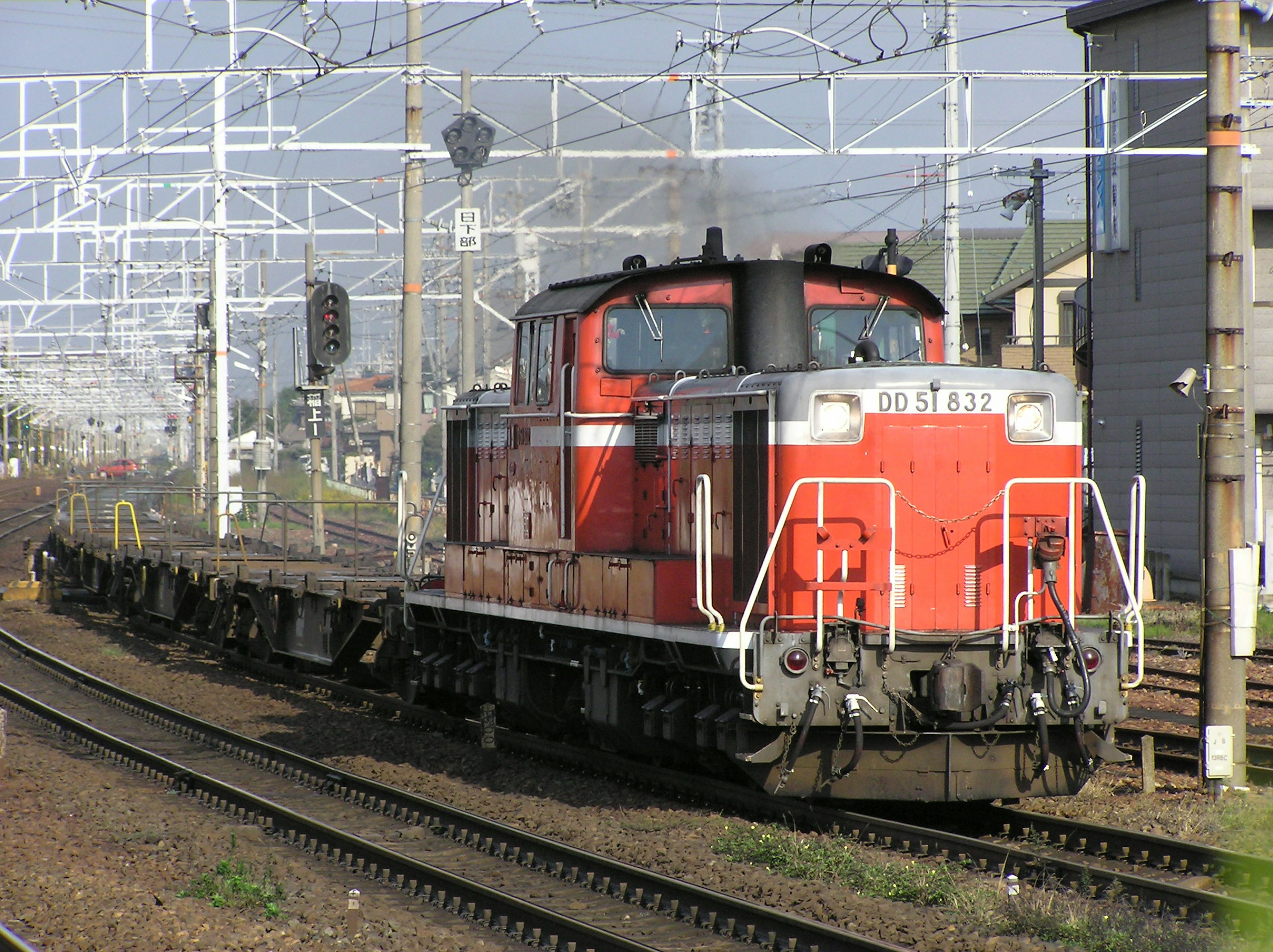 Locomotiva diesel rossa che traina un treno merci in un deposito ferroviario