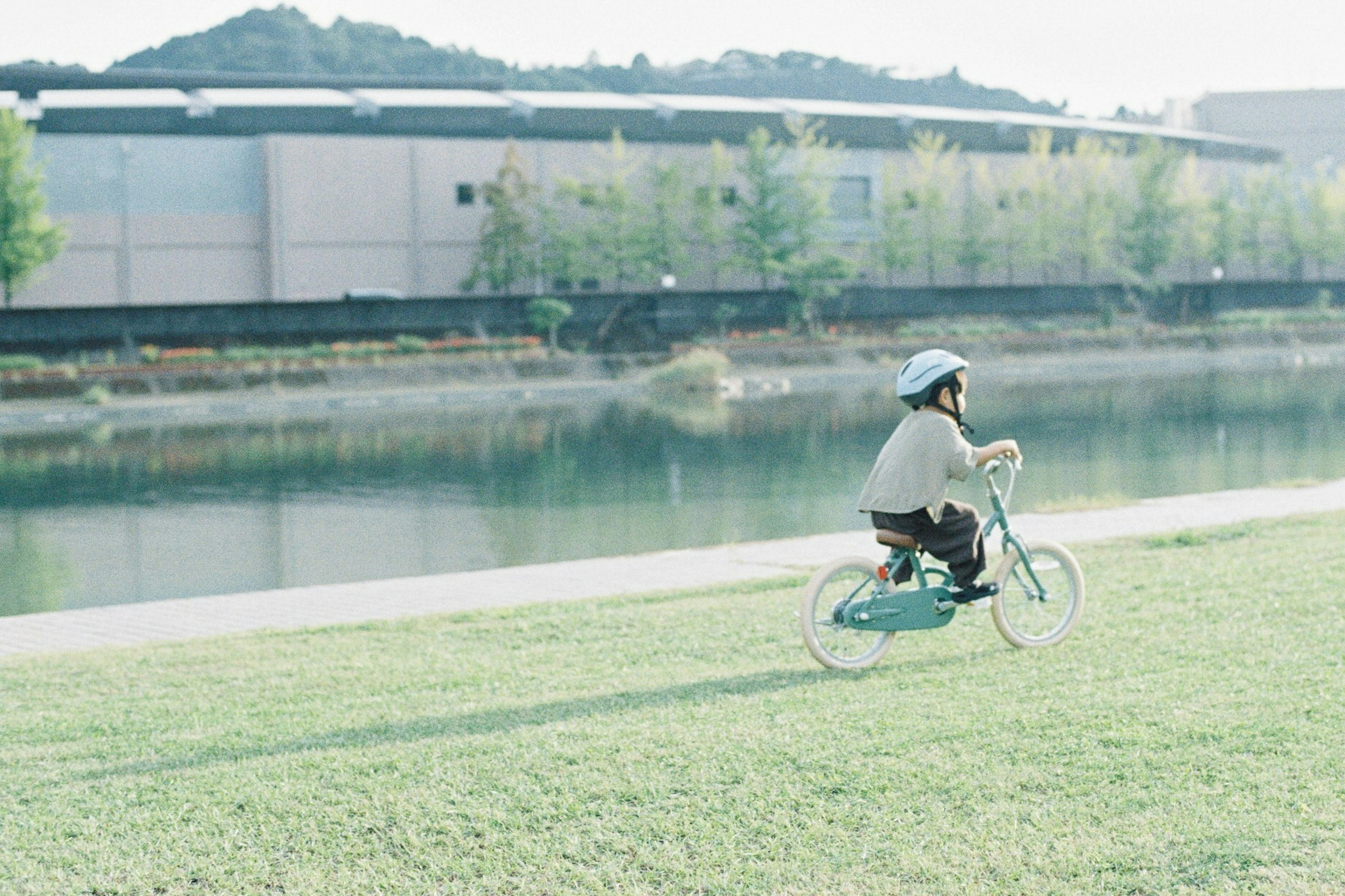 川のそばで自転車に乗る子供の姿