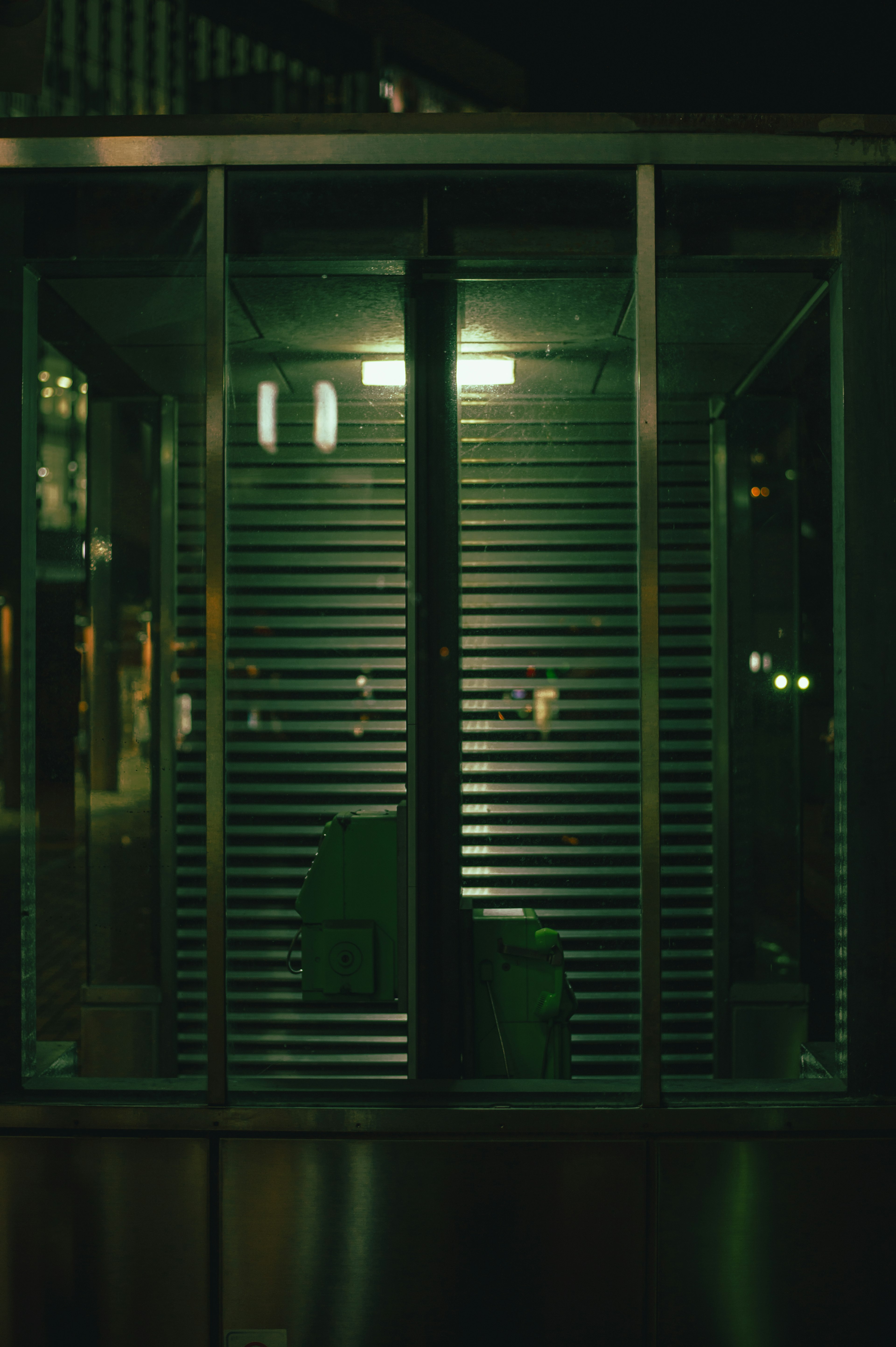 Interior of an empty phone booth in a dimly lit environment