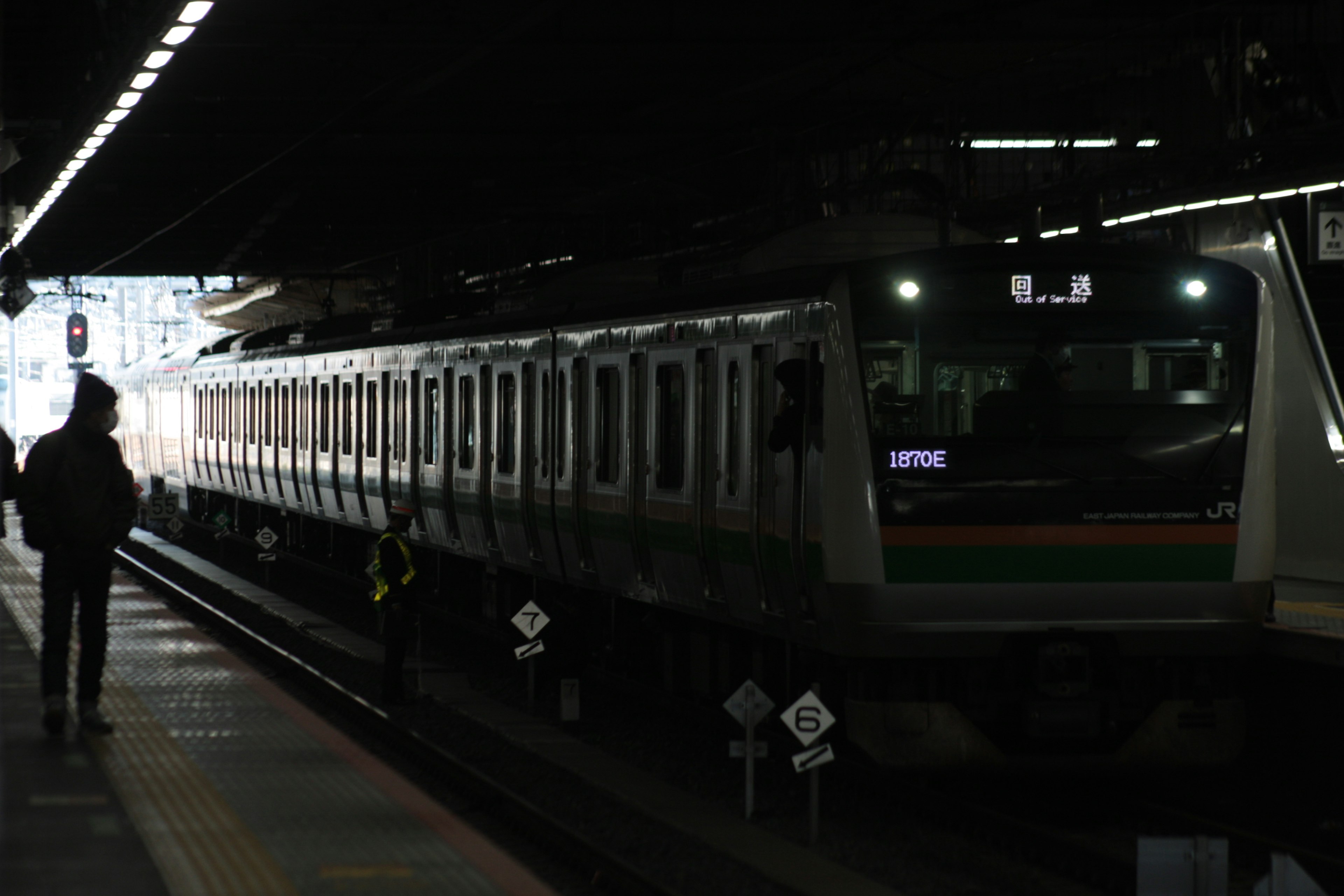 Train dans une gare faiblement éclairée avec la silhouette d'un passager