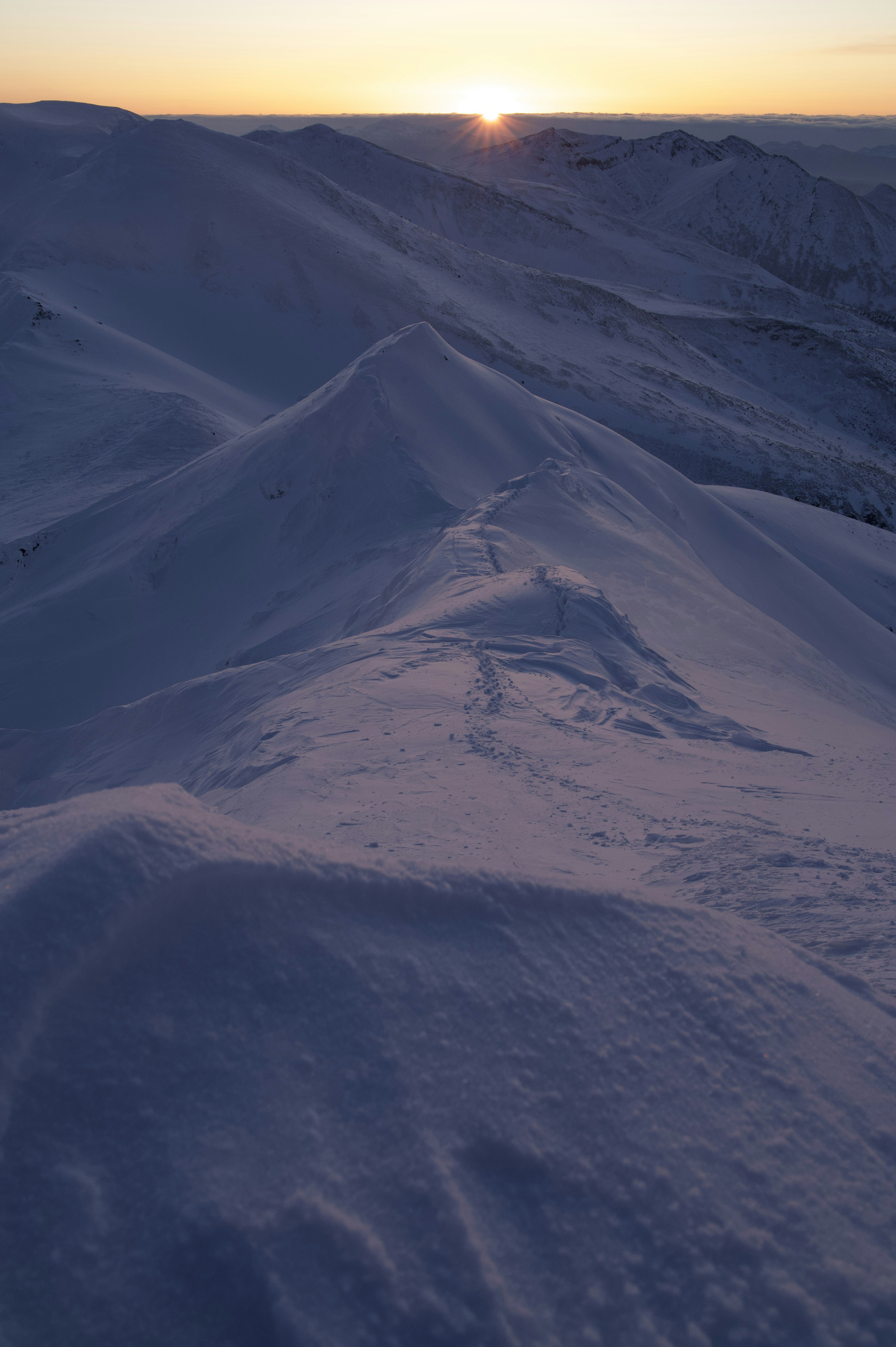 雪に覆われた山々と日の出の景色