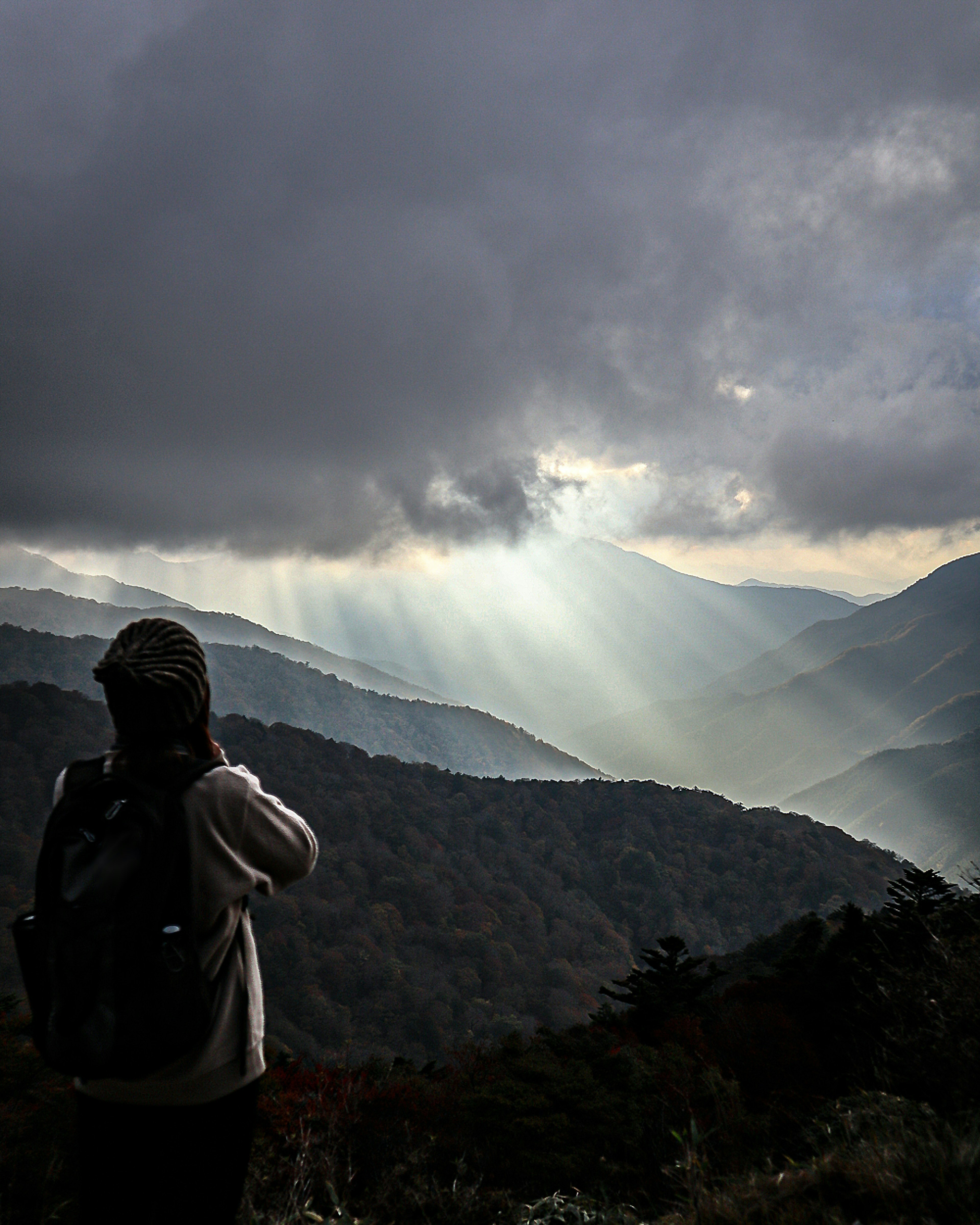 山景背景下的徒步旅行者轮廓与光束