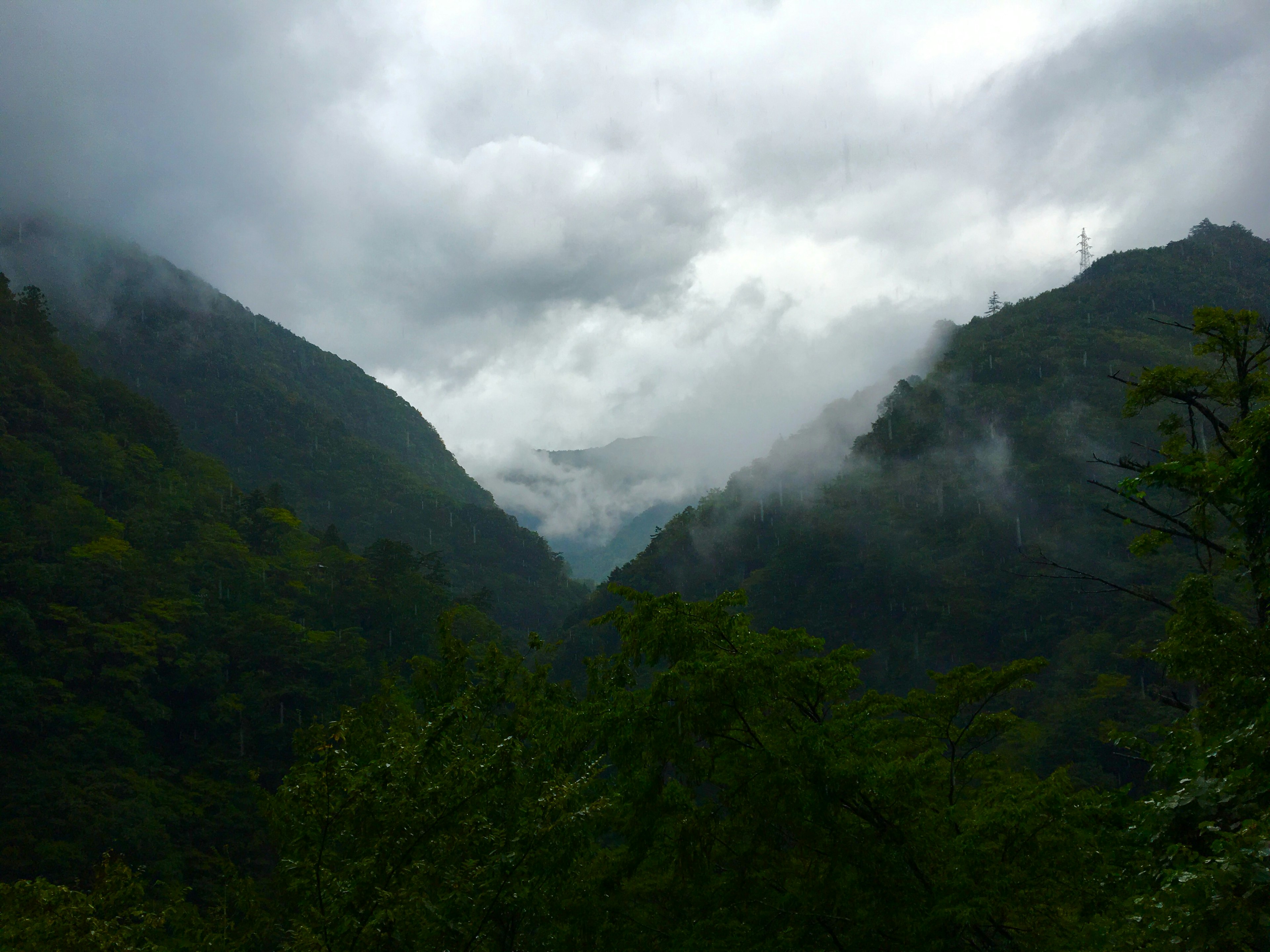 Misty mountains with lush green valleys under a cloudy sky