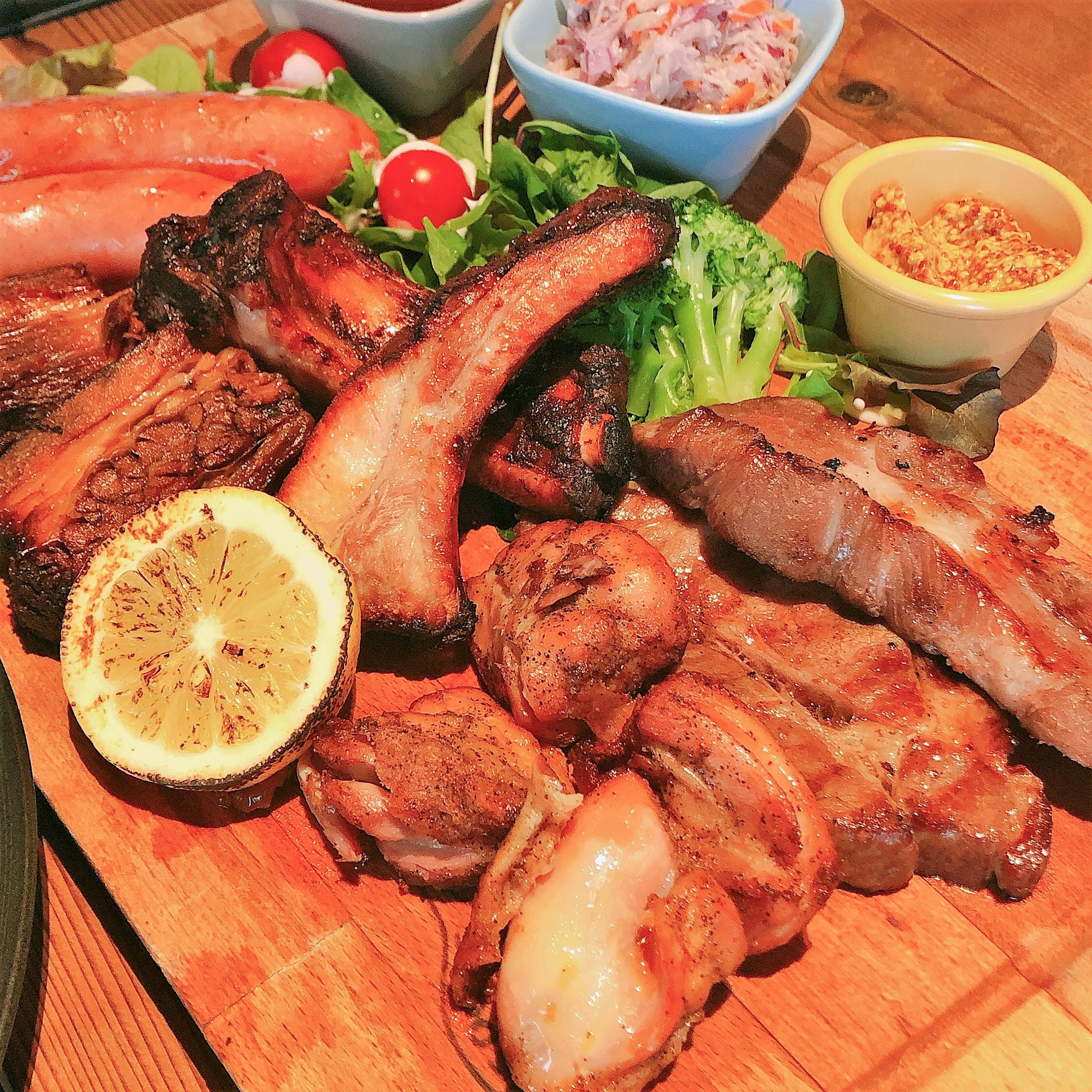 Plato de carnes a la parrilla con limón y guarnición de ensalada