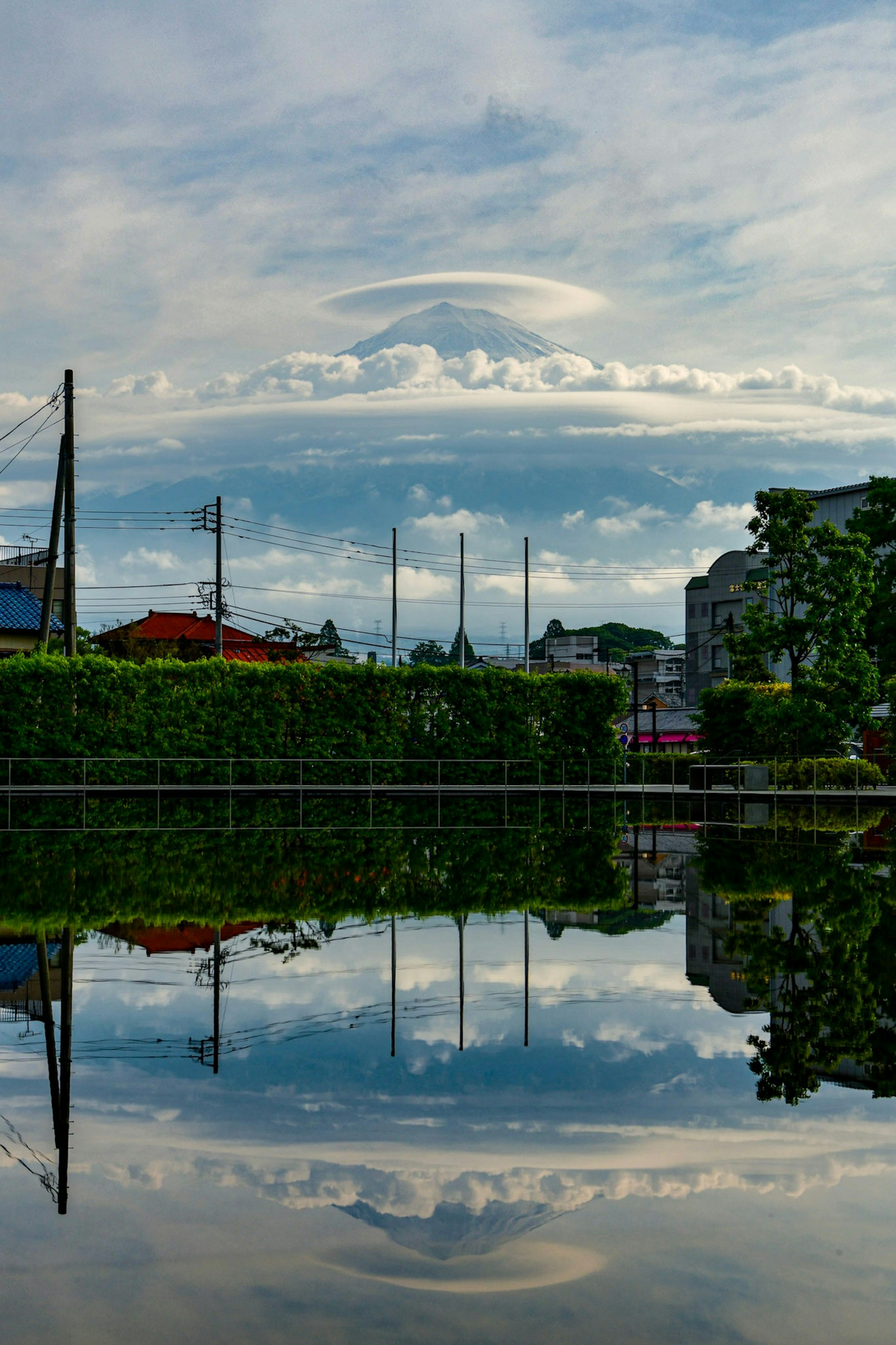 静かな湖の上に広がる雲の層とその反映