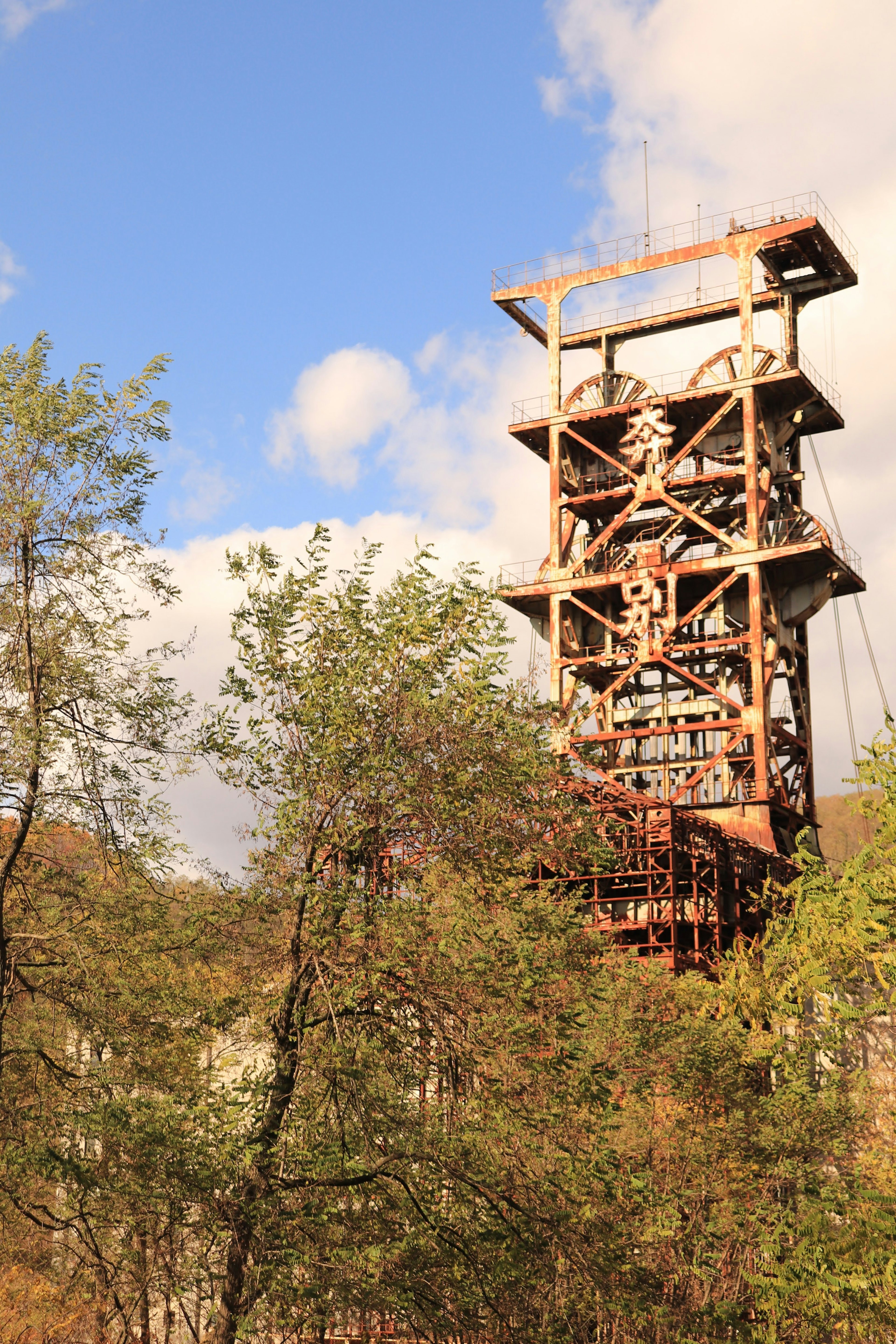 Old mining shaft tower surrounded by trees