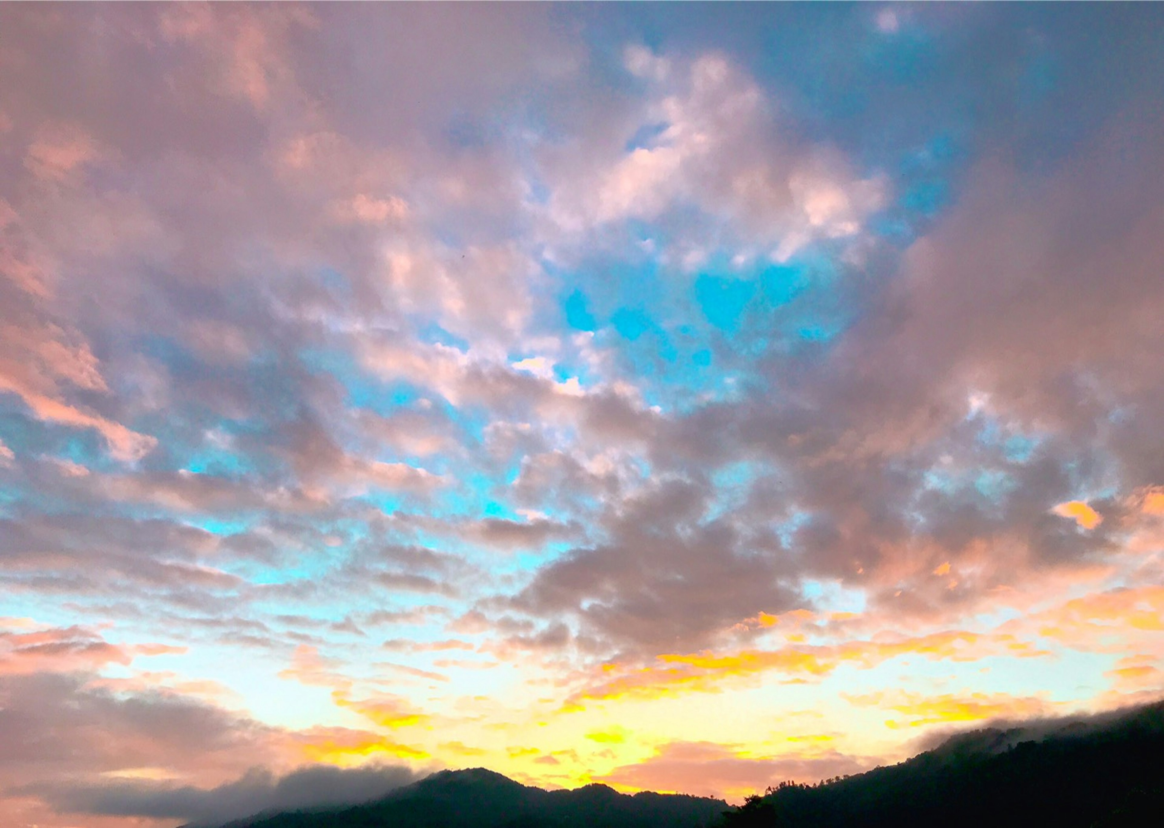 Hermoso paisaje de atardecer con montañas y nubes coloridas