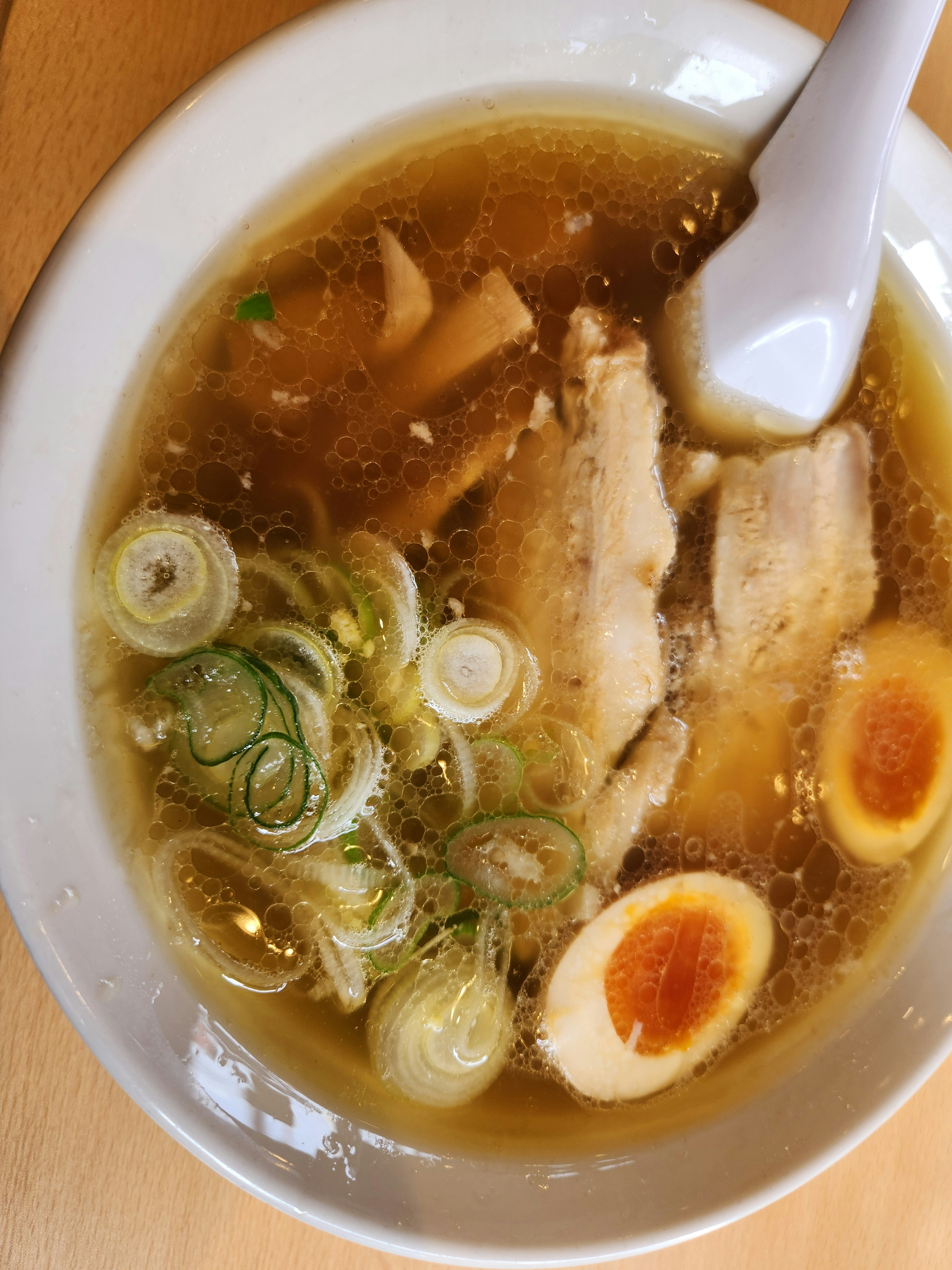 Bowl of ramen with chicken slices and soft-boiled eggs in broth