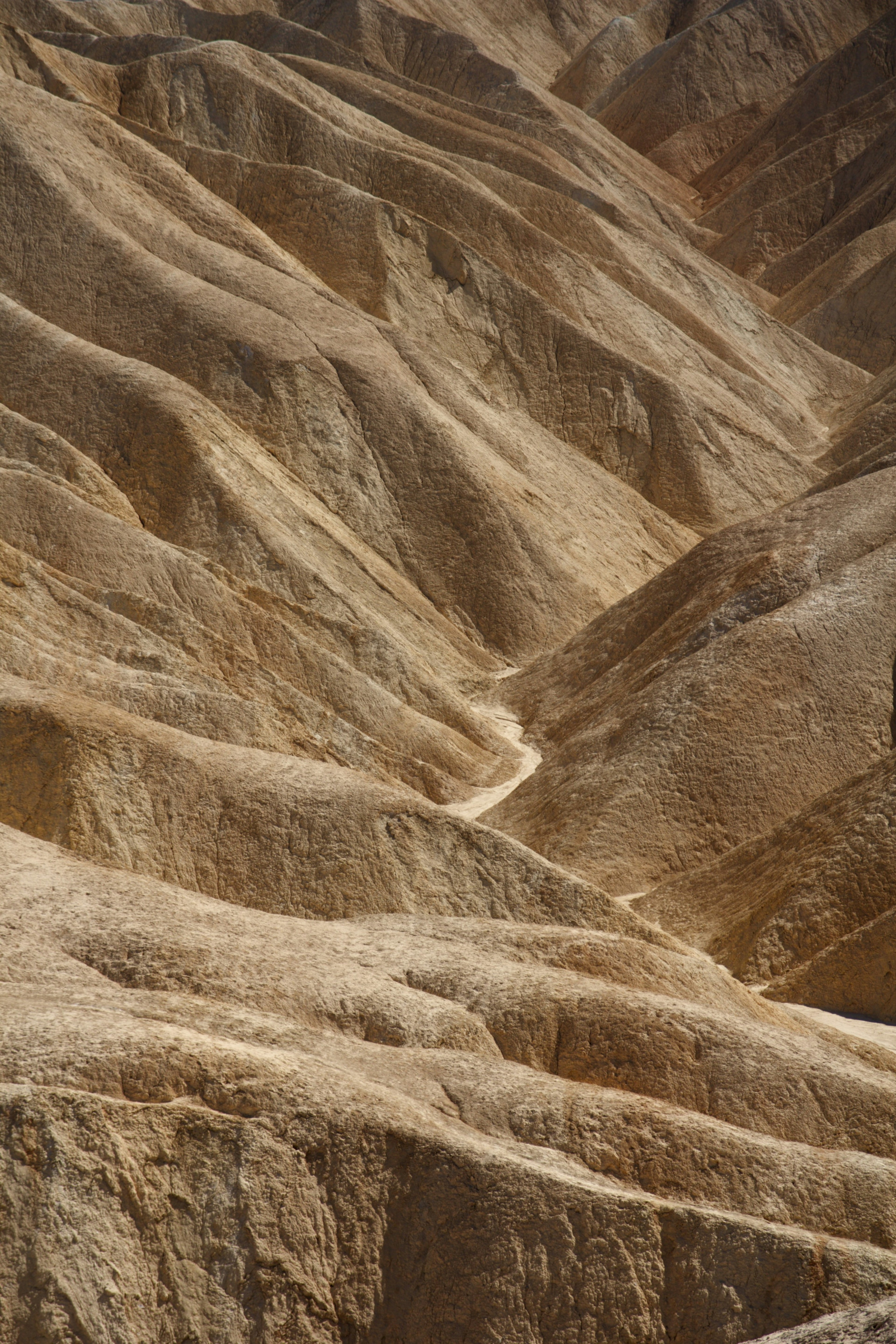 Winding path through arid landscape with layered earth formations