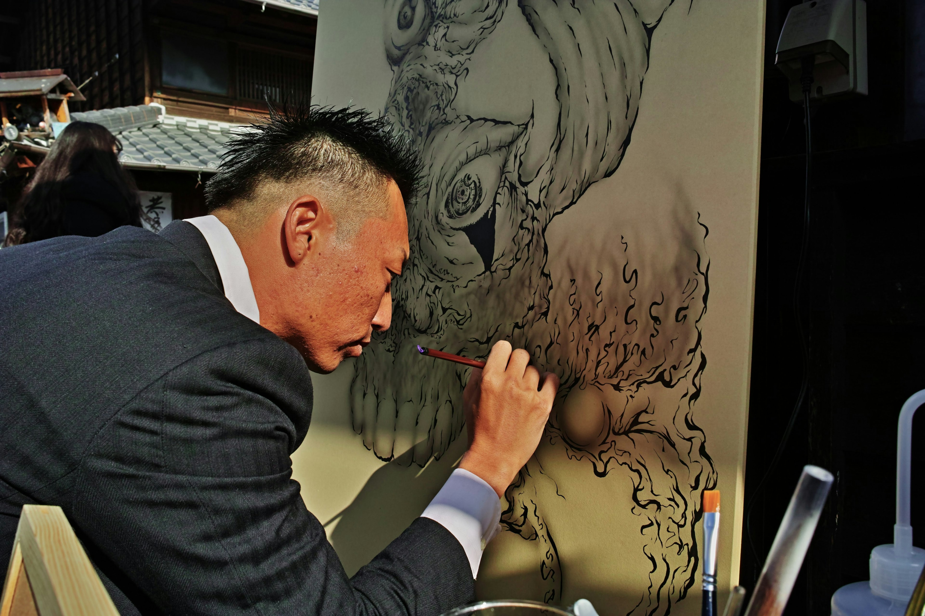 一名穿著西裝的男士在畫布上作畫