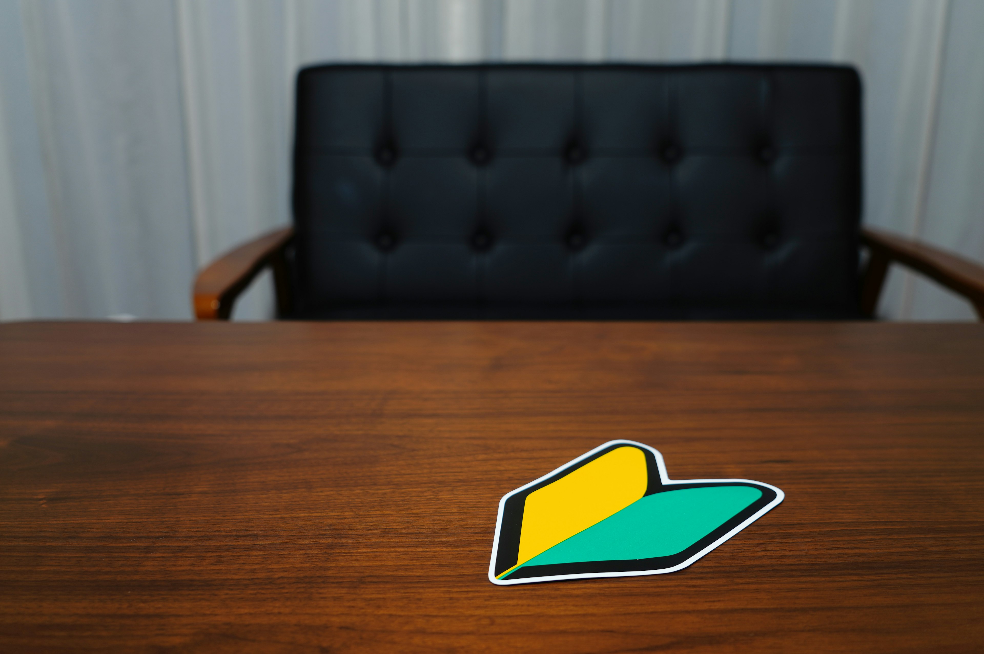 Colorful sticker on a wooden table near a black leather chair