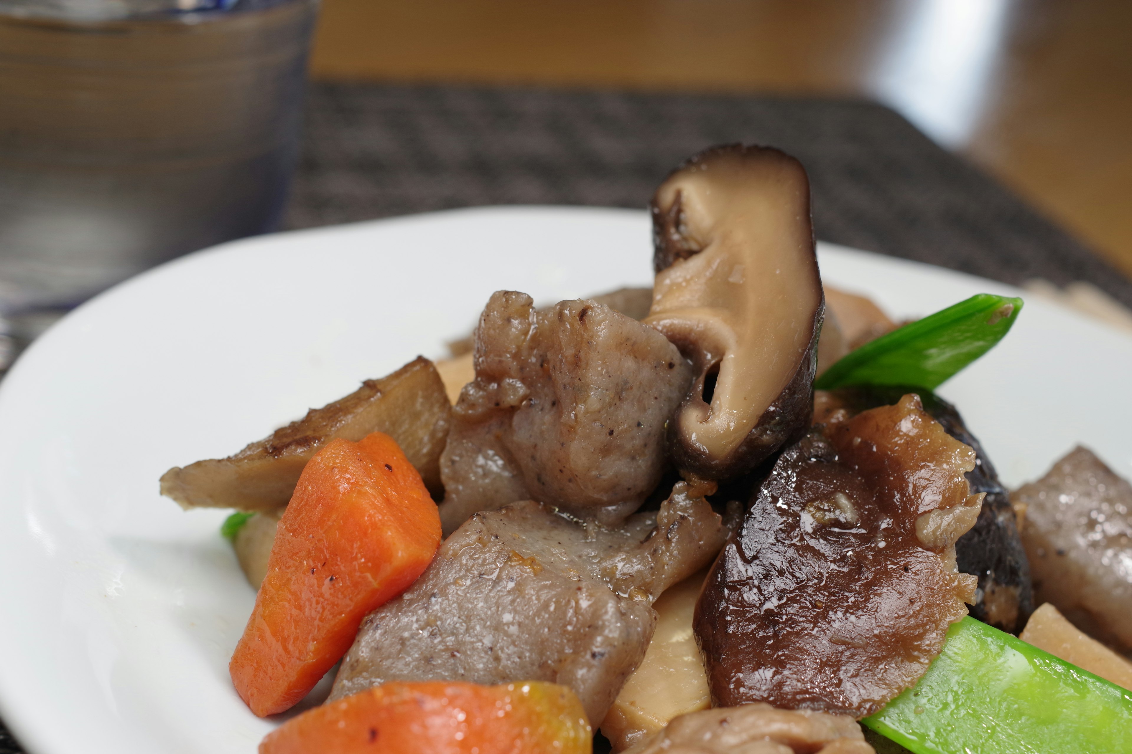 Un salteado colorido de verduras y champiñones servido en un plato blanco