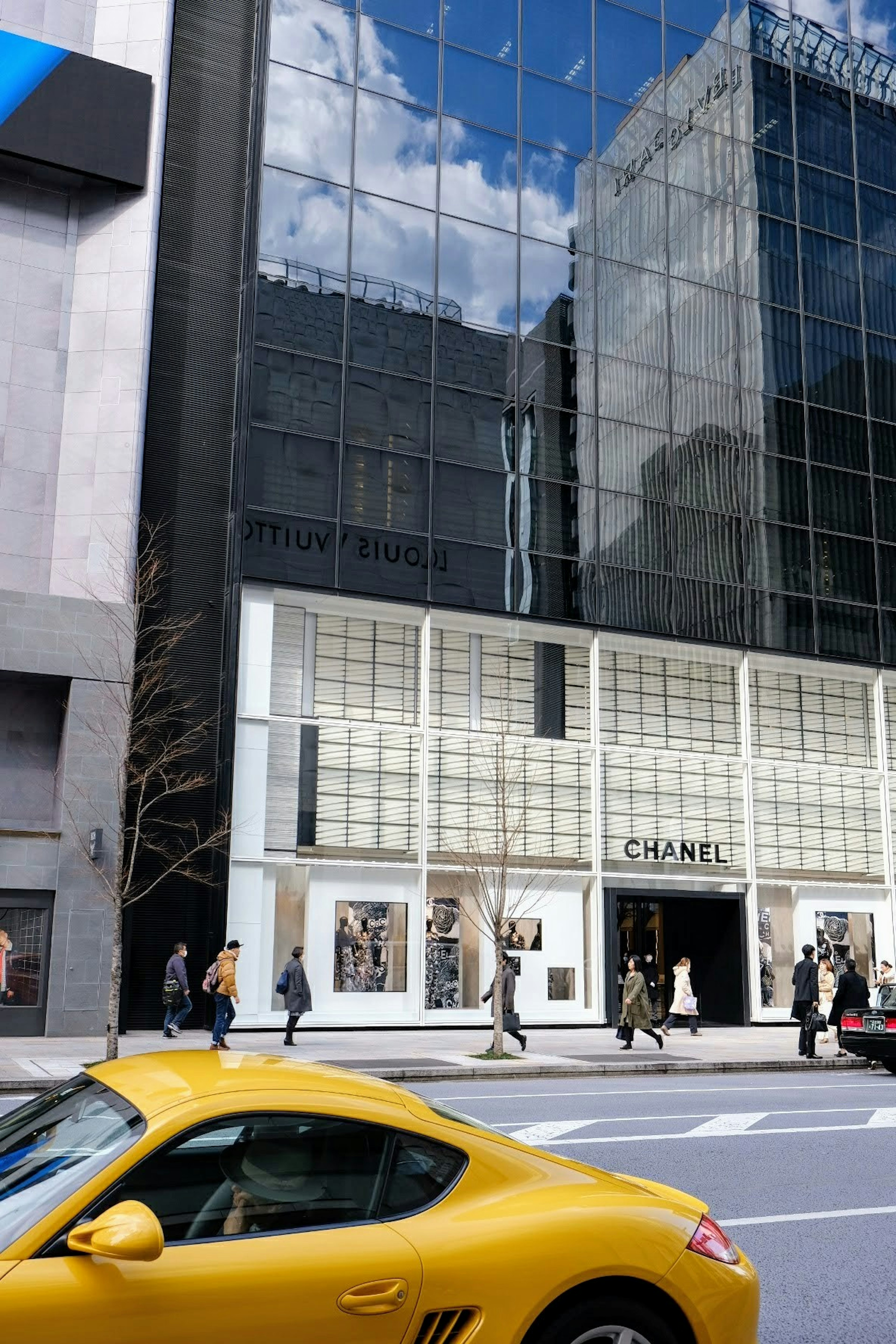 Magasin Chanel avec façade en verre et voiture jaune