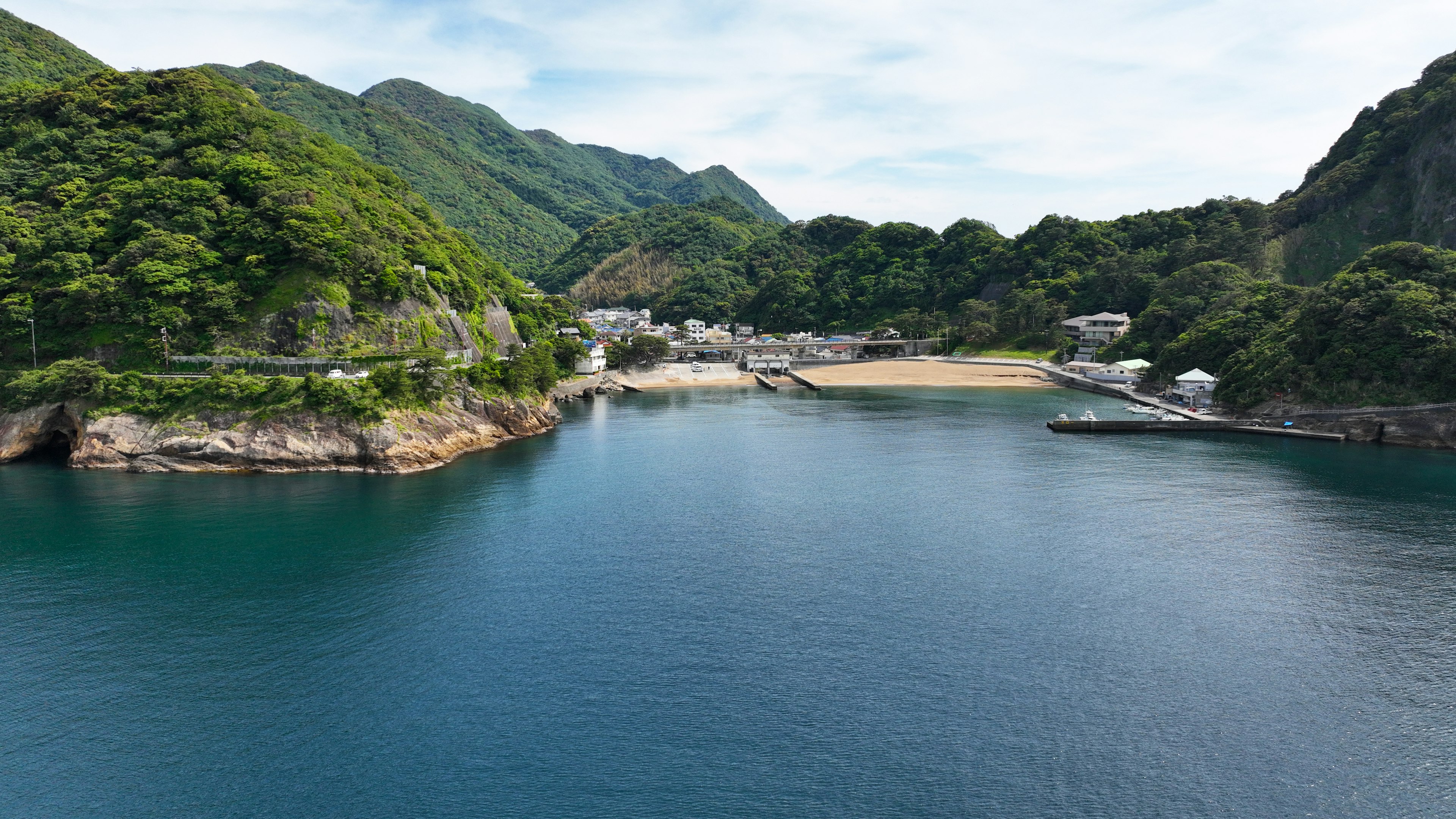 Scenic view of a tranquil bay surrounded by lush green mountains