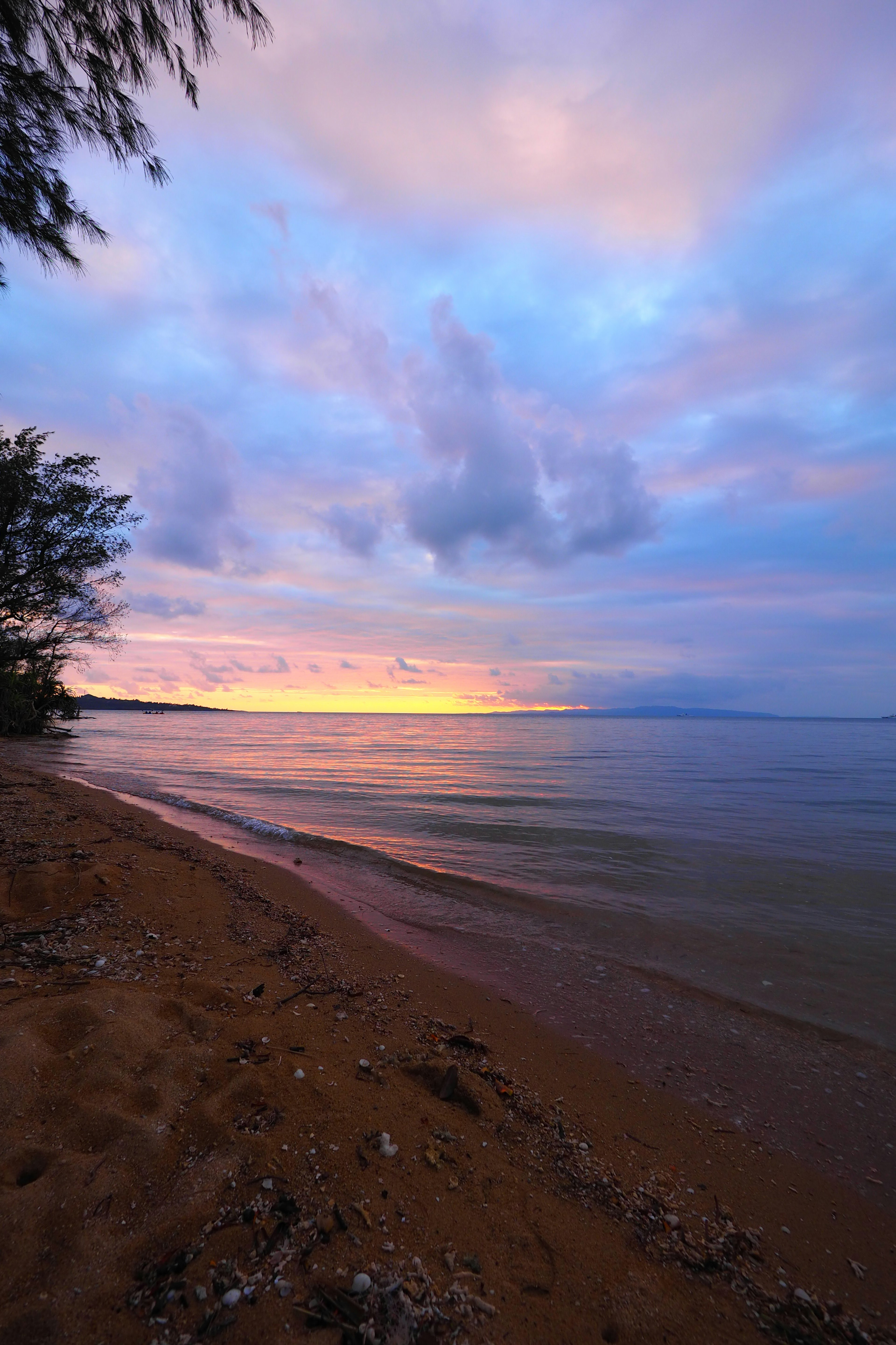 Hermosa costa al atardecer con cielo azul y nubes moradas playa de arena