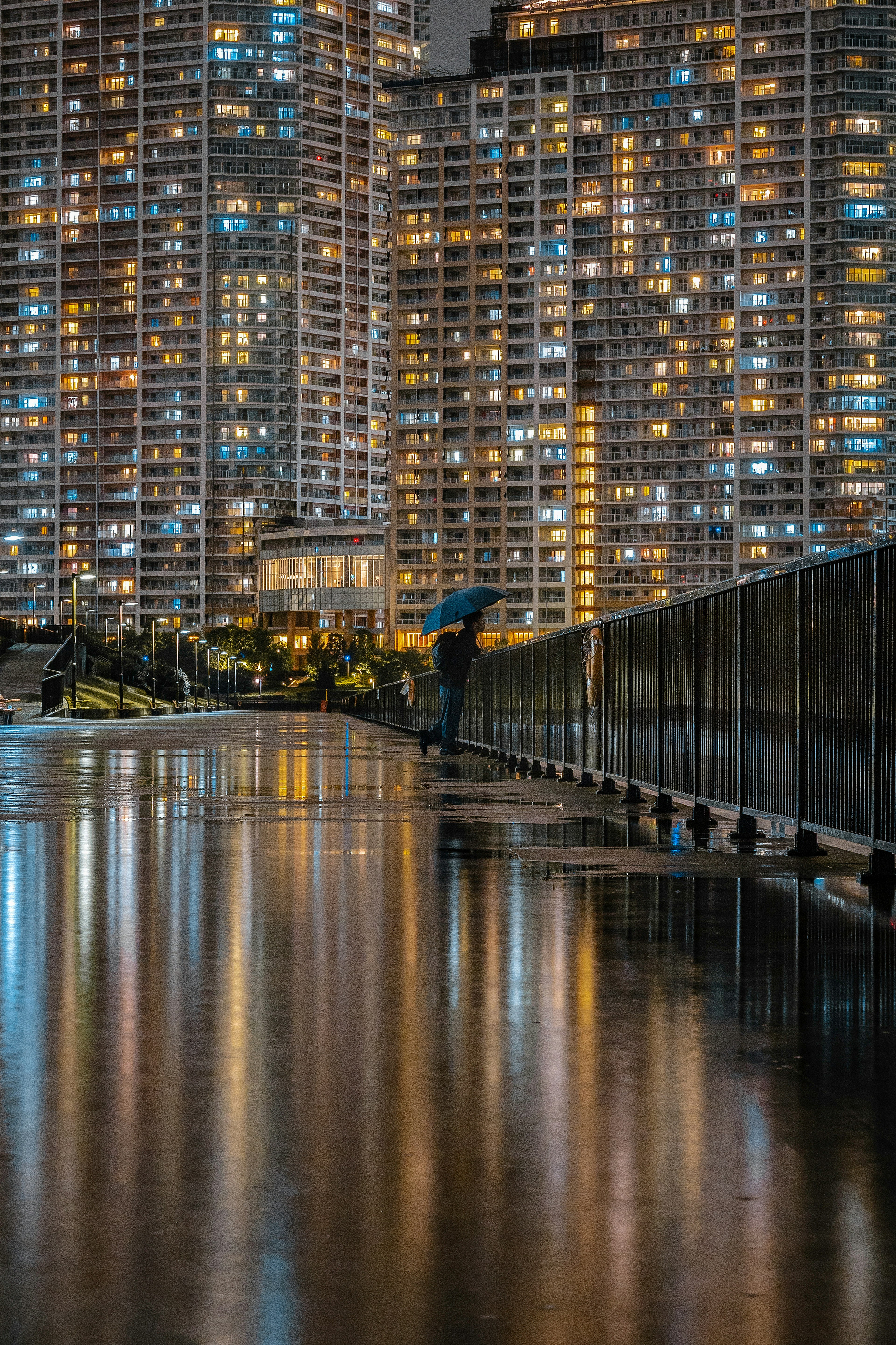 夜晚城市风光，高楼灯光的倒影和湿滑的人行道