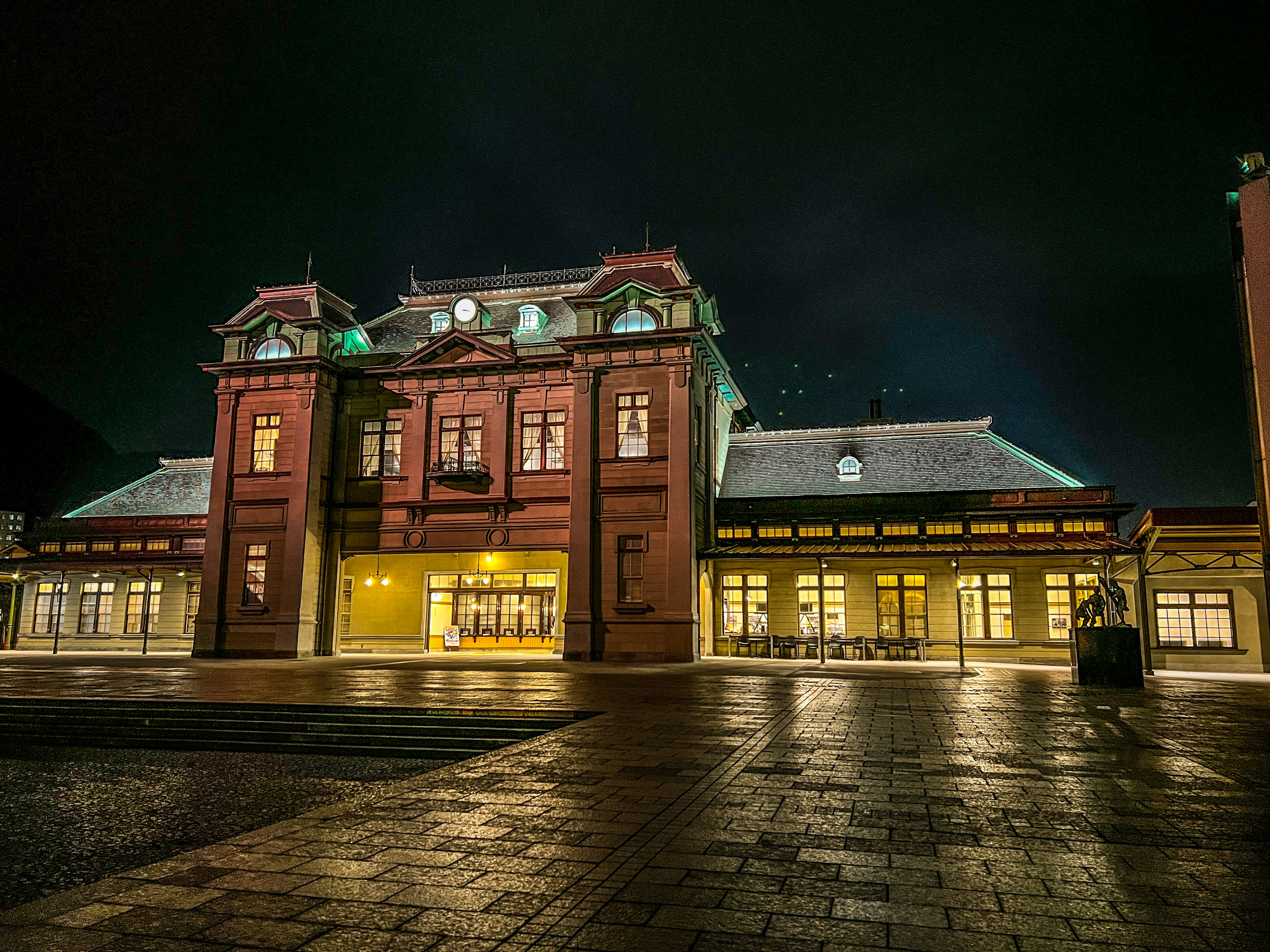 夜间照亮的历史红砖建筑，明亮的窗户和建筑细节