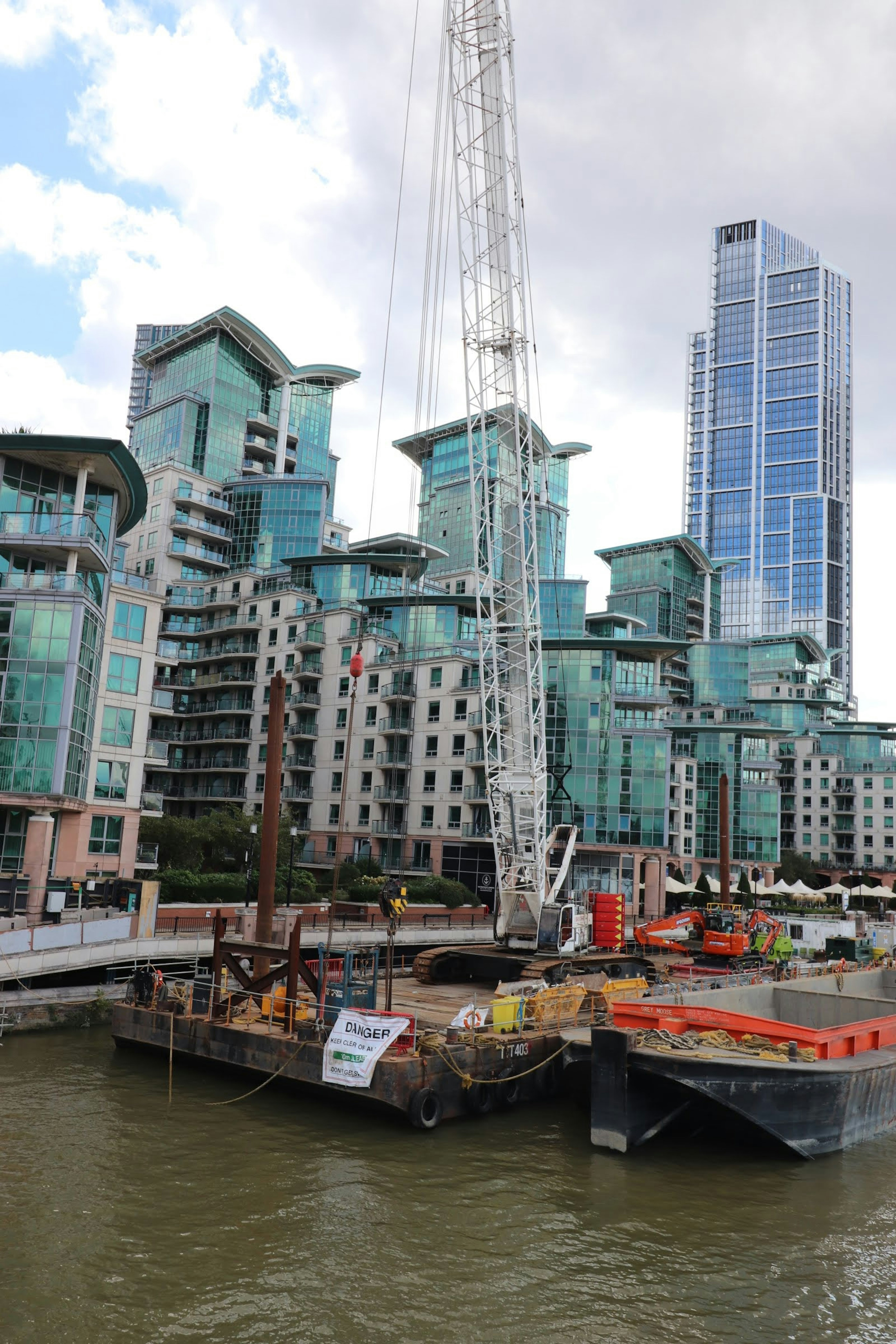 ロンドンの高層ビルと建設クレーンがある川沿いの景観