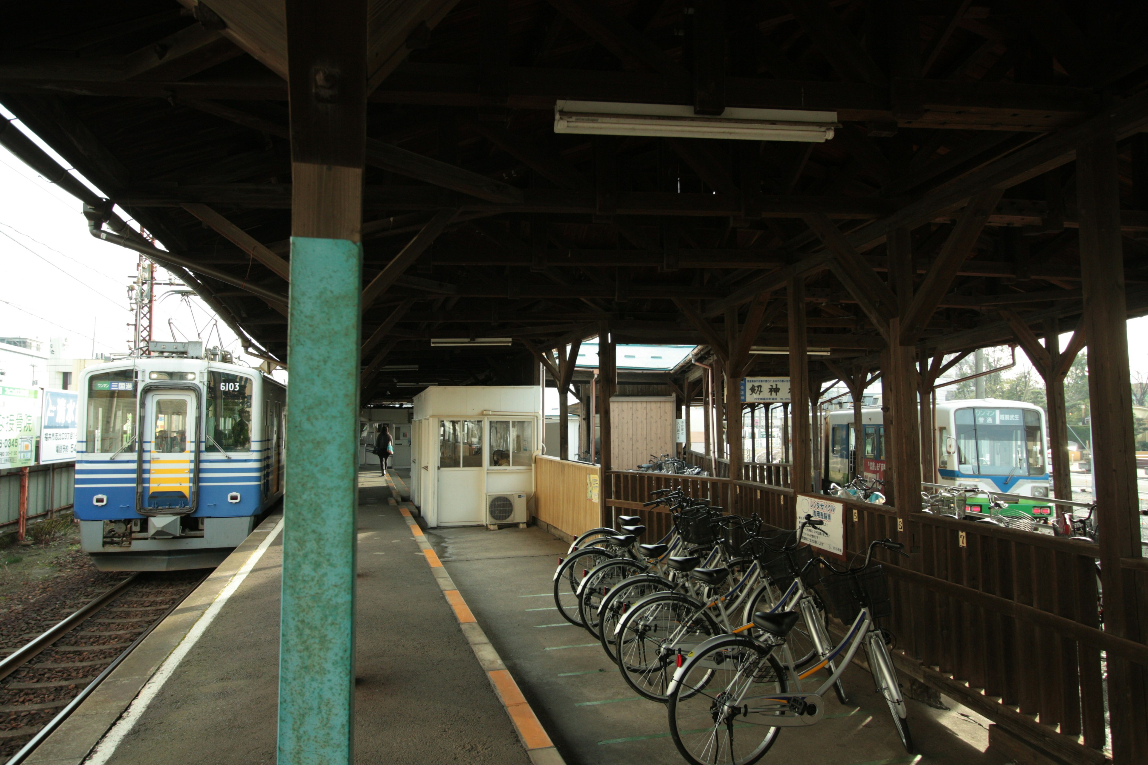 Train at a platform with bicycle racks in a wooden station