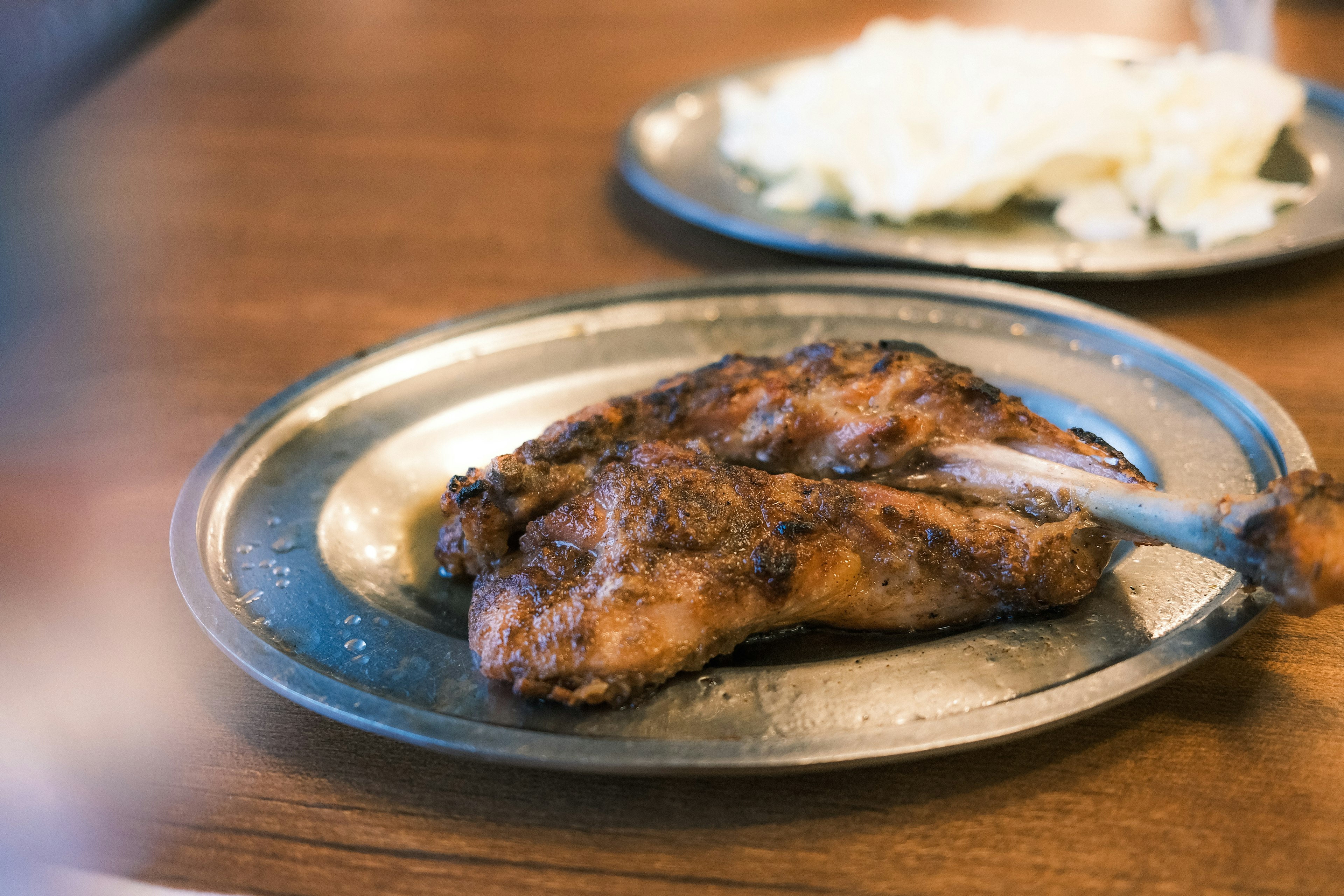 Pollo grigliato succulento su un piatto di metallo con riso bianco