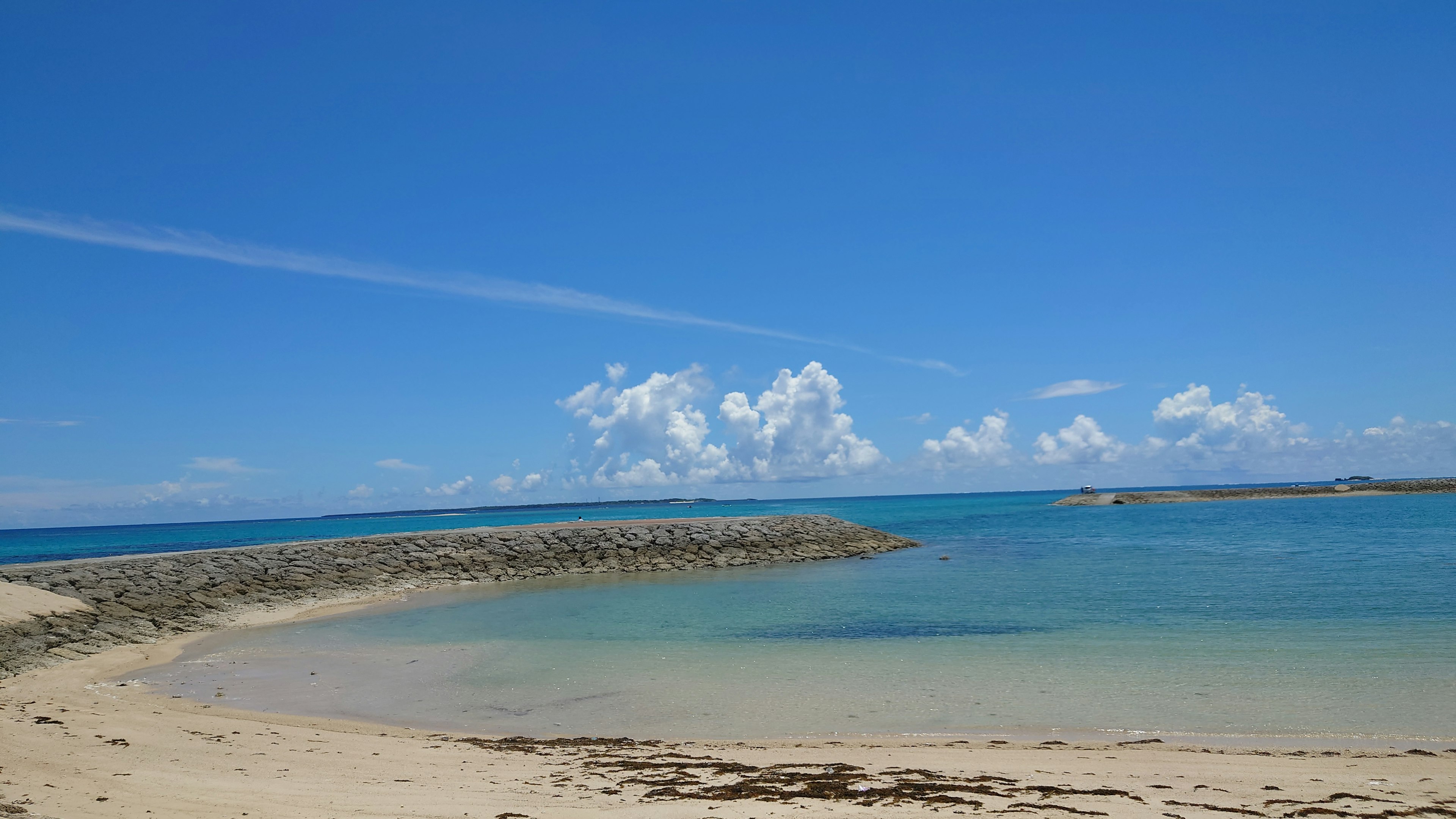 Vue de plage pittoresque avec ciel bleu et nuages eaux calmes et rivage de sable