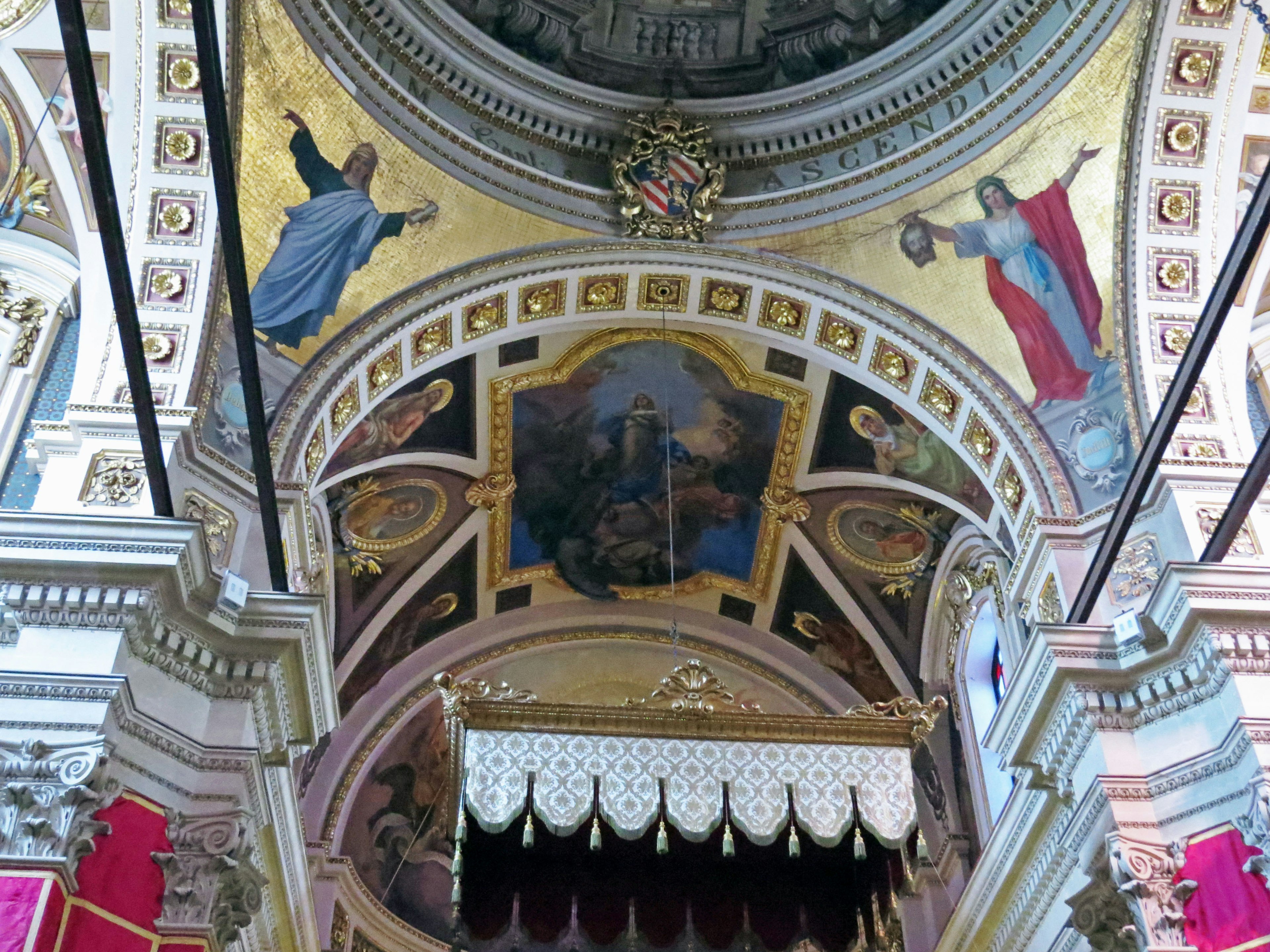 Techo de iglesia bellamente decorado con adornos dorados e imágenes de santos