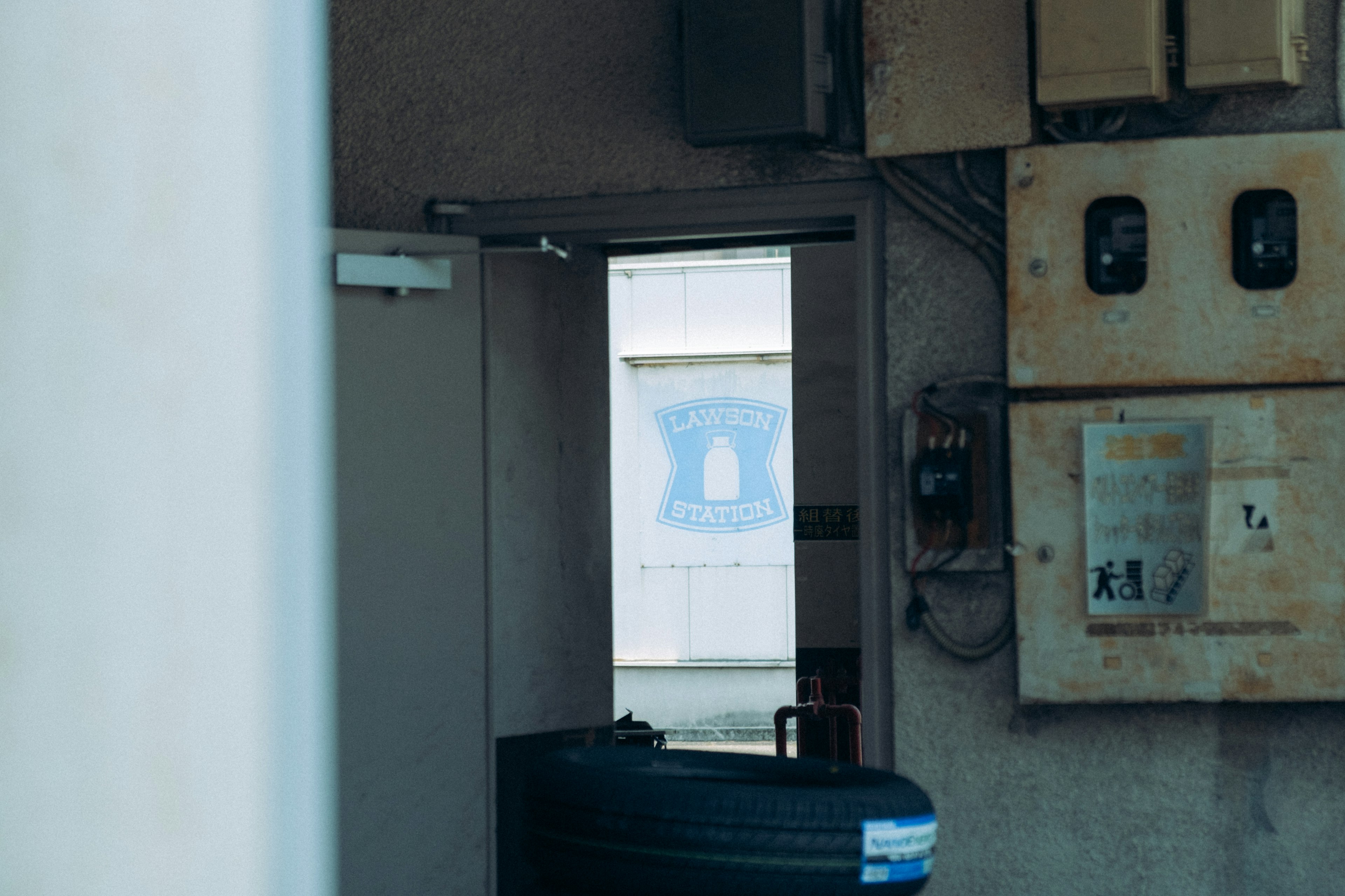 View through a door showing a blue design on the wall and electrical meters