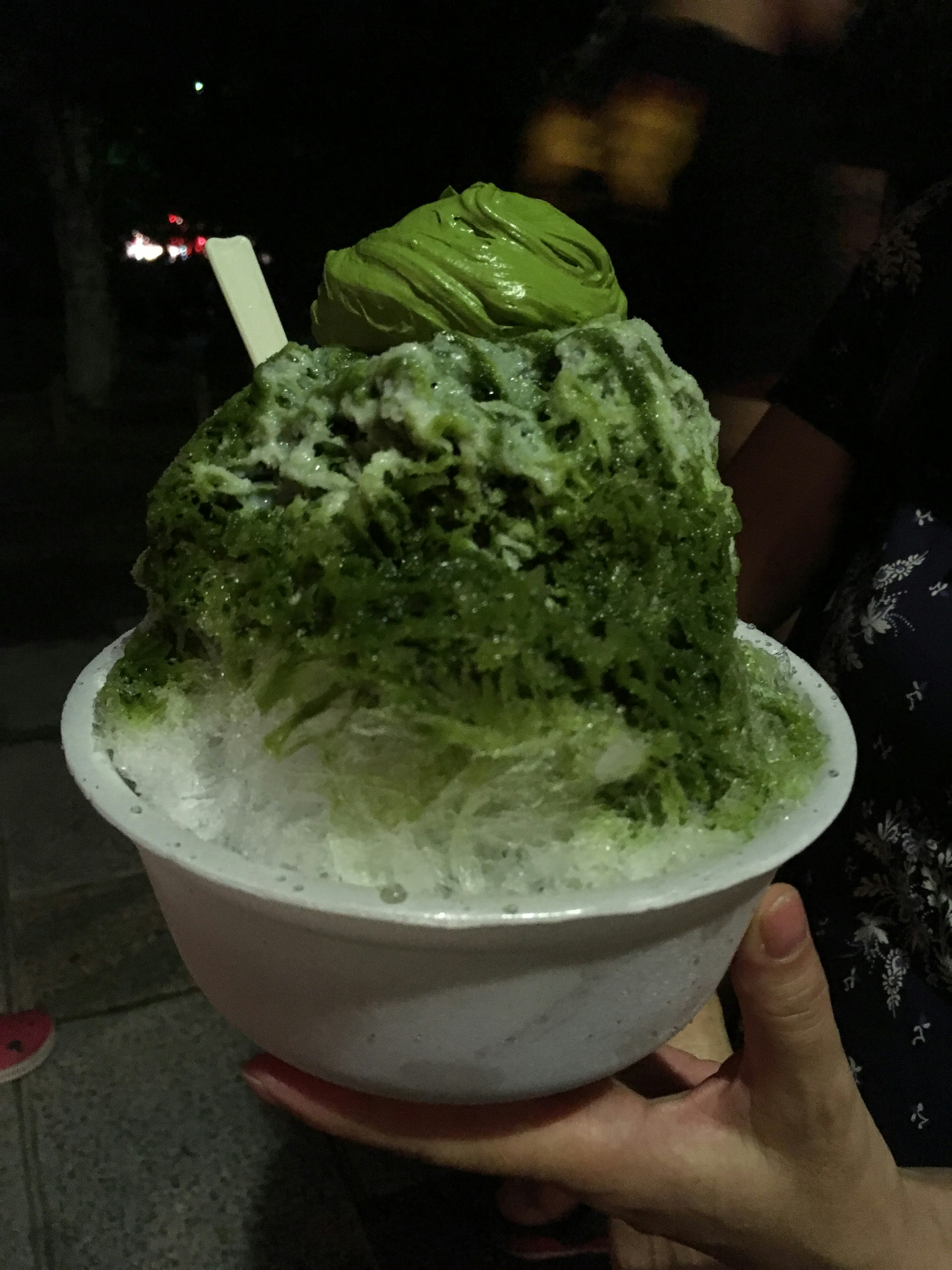 Un postre con un montón de hielo rallado de té verde cubierto con helado de té verde