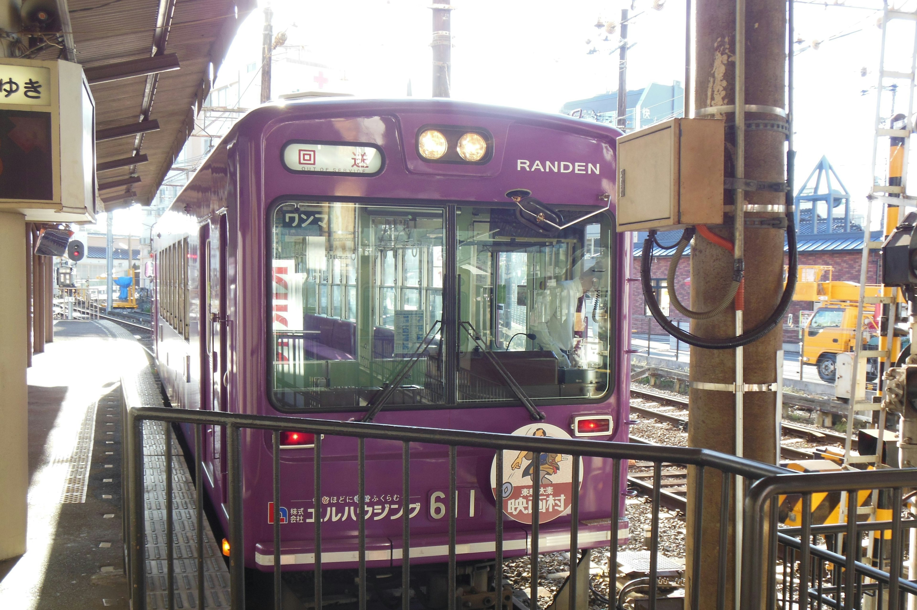 A purple train is stopped at a station