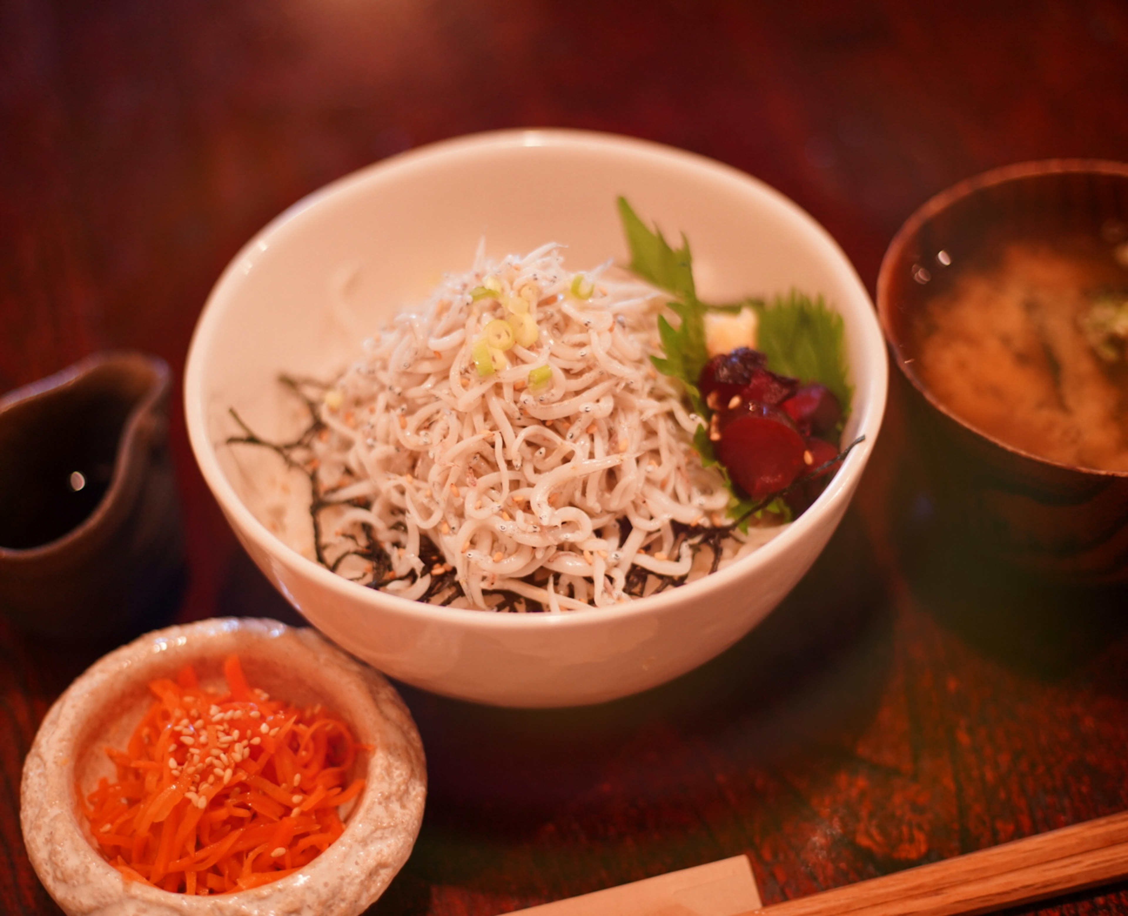 Schüssel mit weißem Fisch und Beilage sowie Miso-Suppe